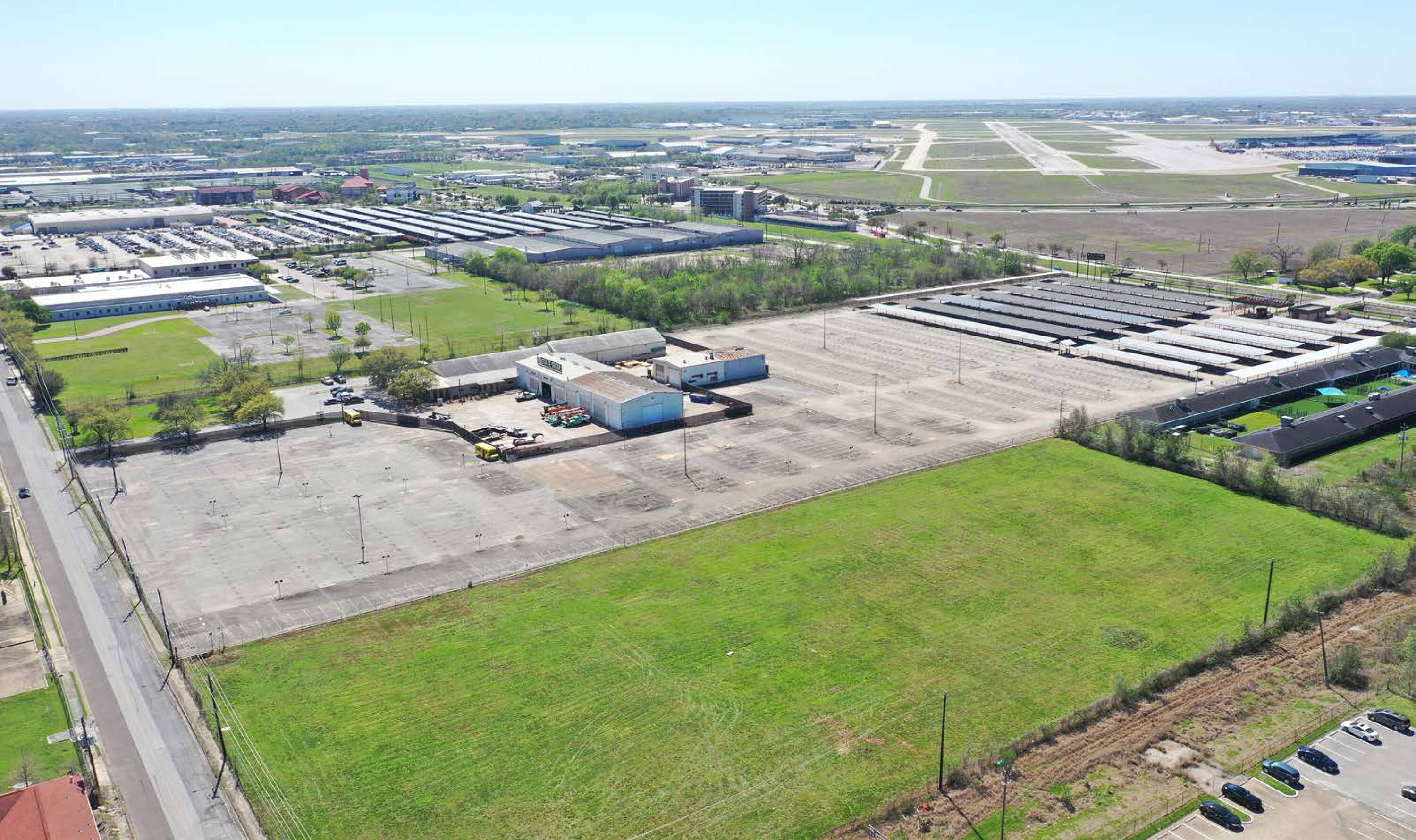 Aerial view of 7625 Monroe Rd, Houston, TX, showing a large vacant land parcel with adjacent industrial buildings and proximity to an airport.