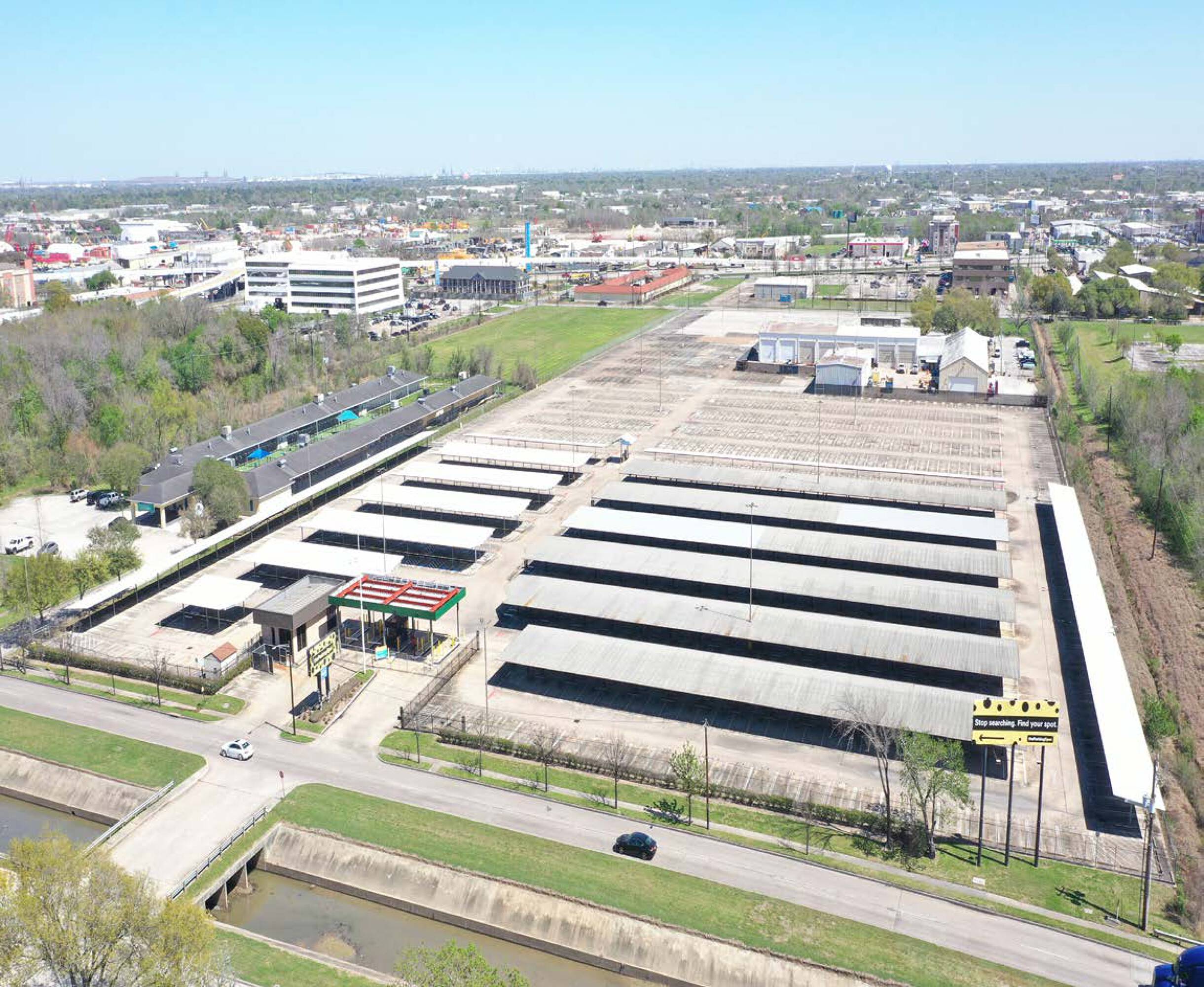 Aerial view of 7625 Monroe Rd, Houston, TX, showcasing industrial land with multiple storage structures and ample parking.