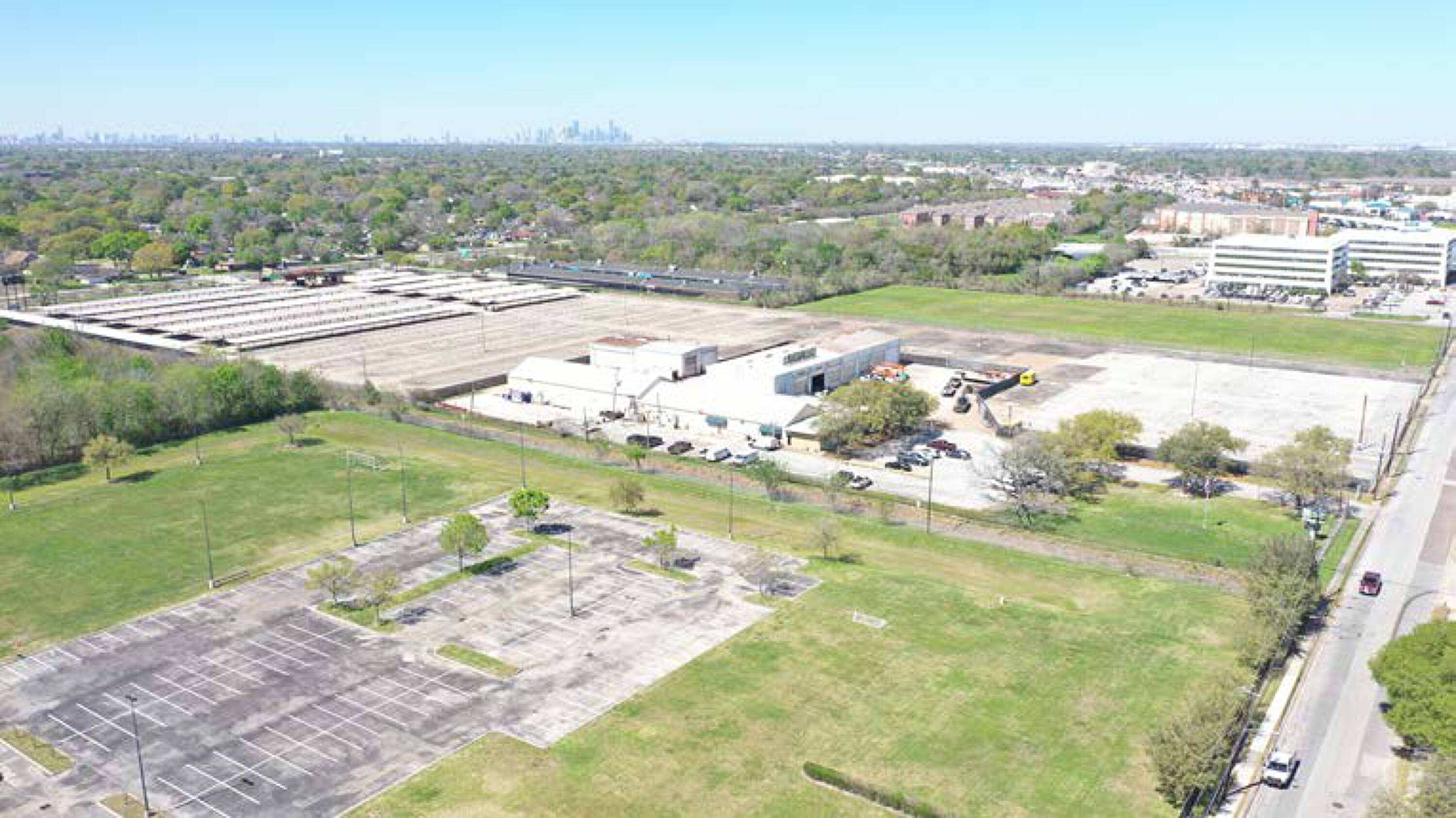 Aerial view of 7625 Monroe Rd, Houston, TX, showing vacant land with adjacent industrial buildings and surface parking.