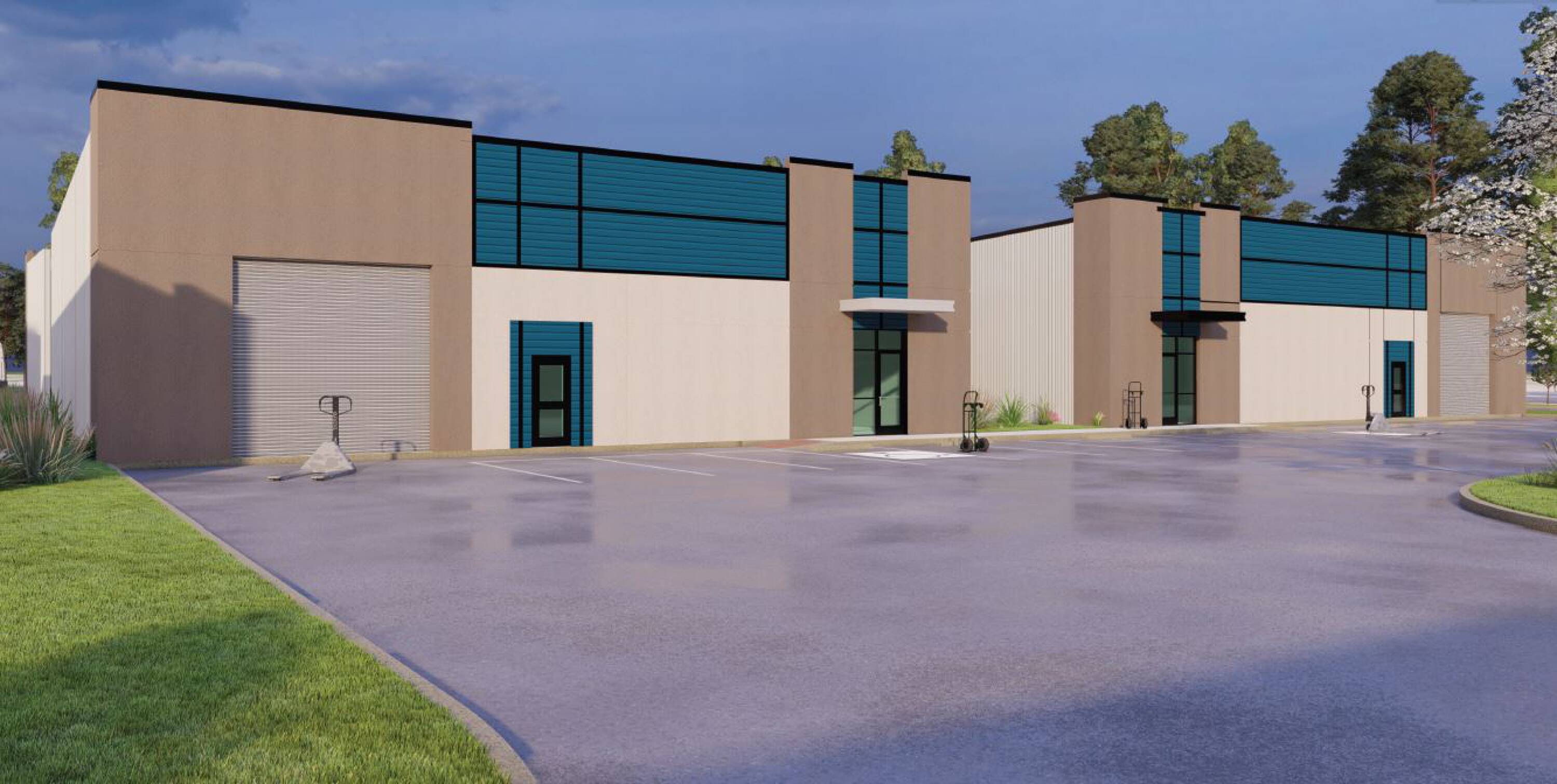 Modern industrial building with large windows, multiple entry points, and spacious parking lot.