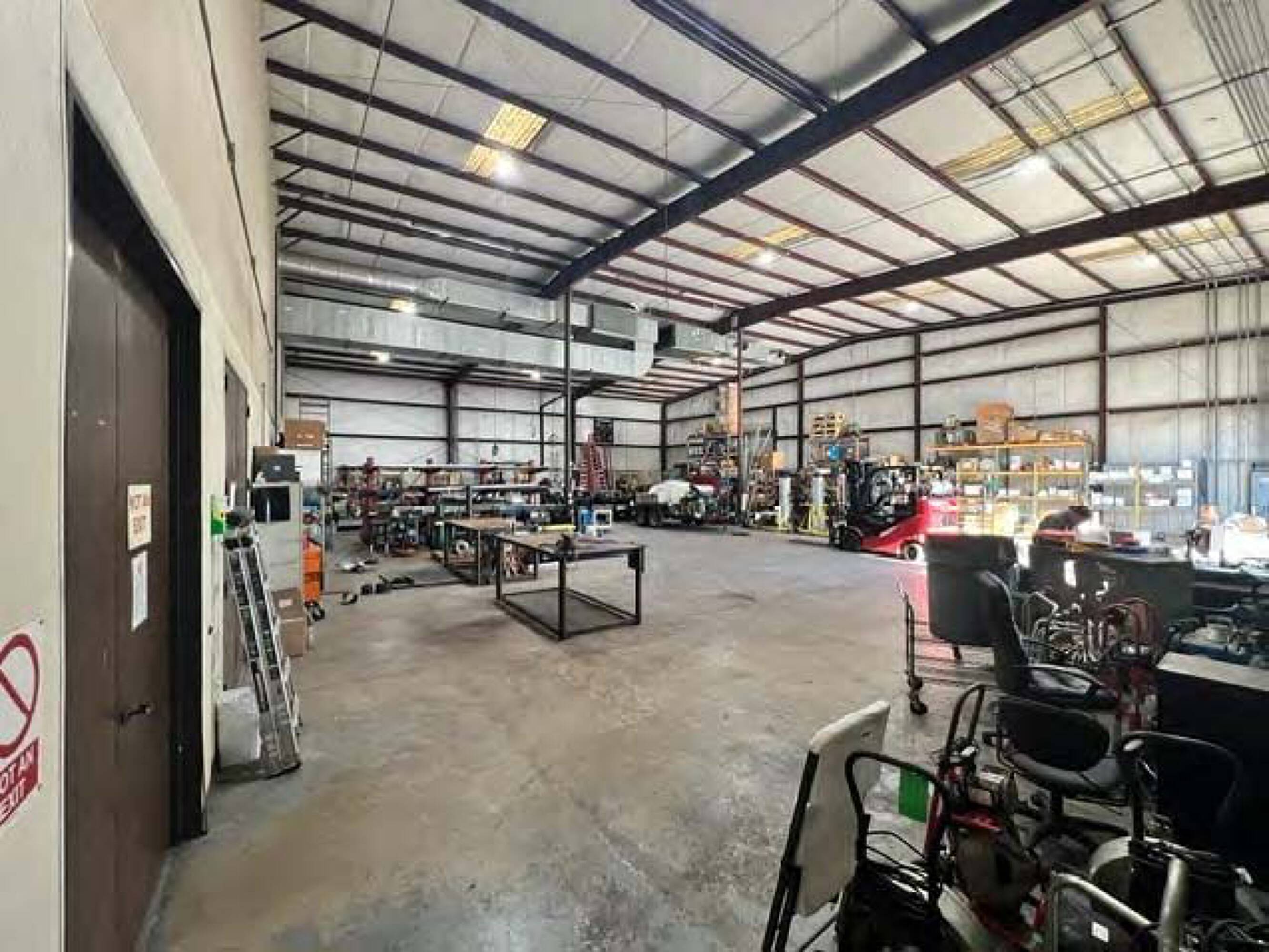 Spacious industrial workshop with high ceilings, ample lighting, and large windows at Four Seasons Business Park.