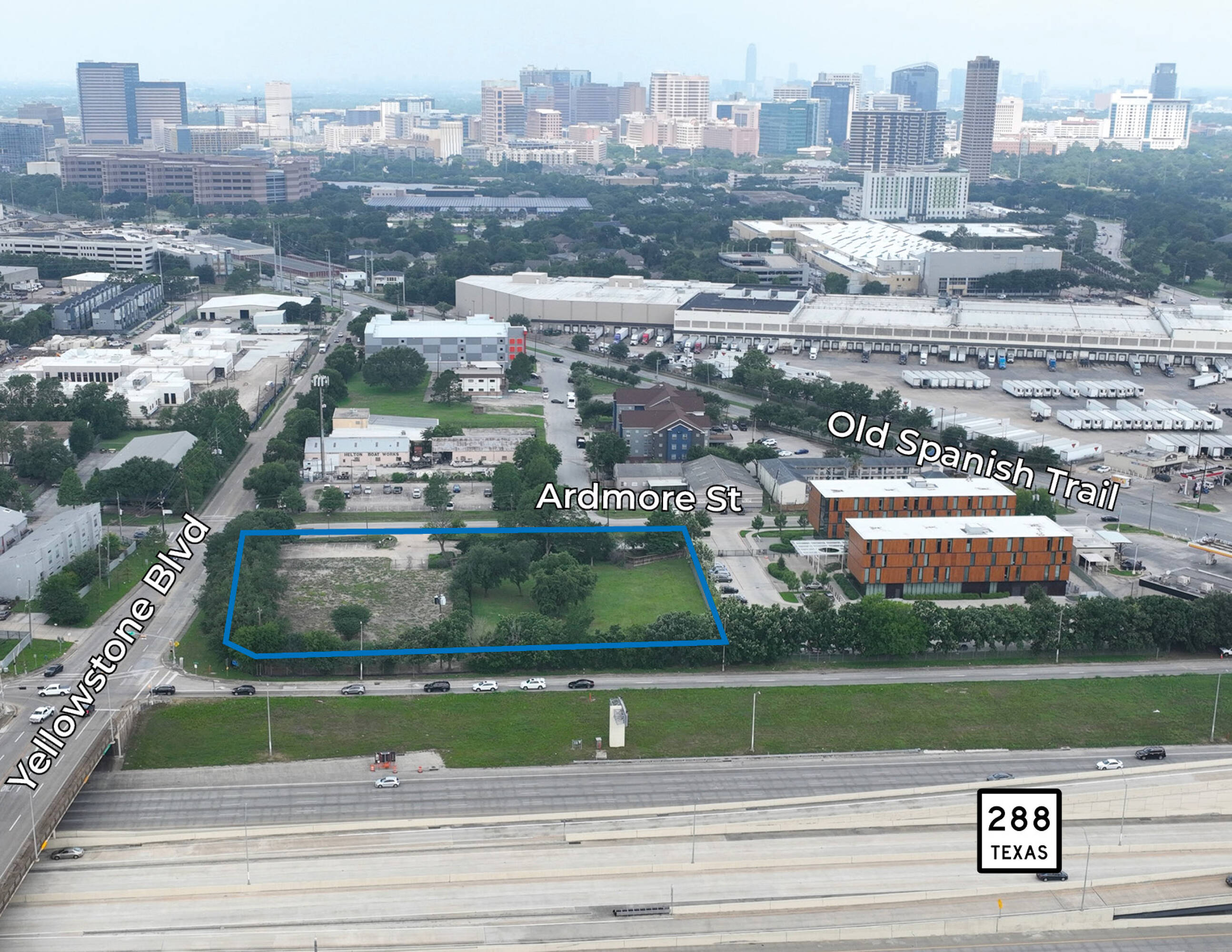 Aerial view of 6897 Ardmore St, Houston, TX, showing a vacant land parcel surrounded by commercial buildings and near major highways.