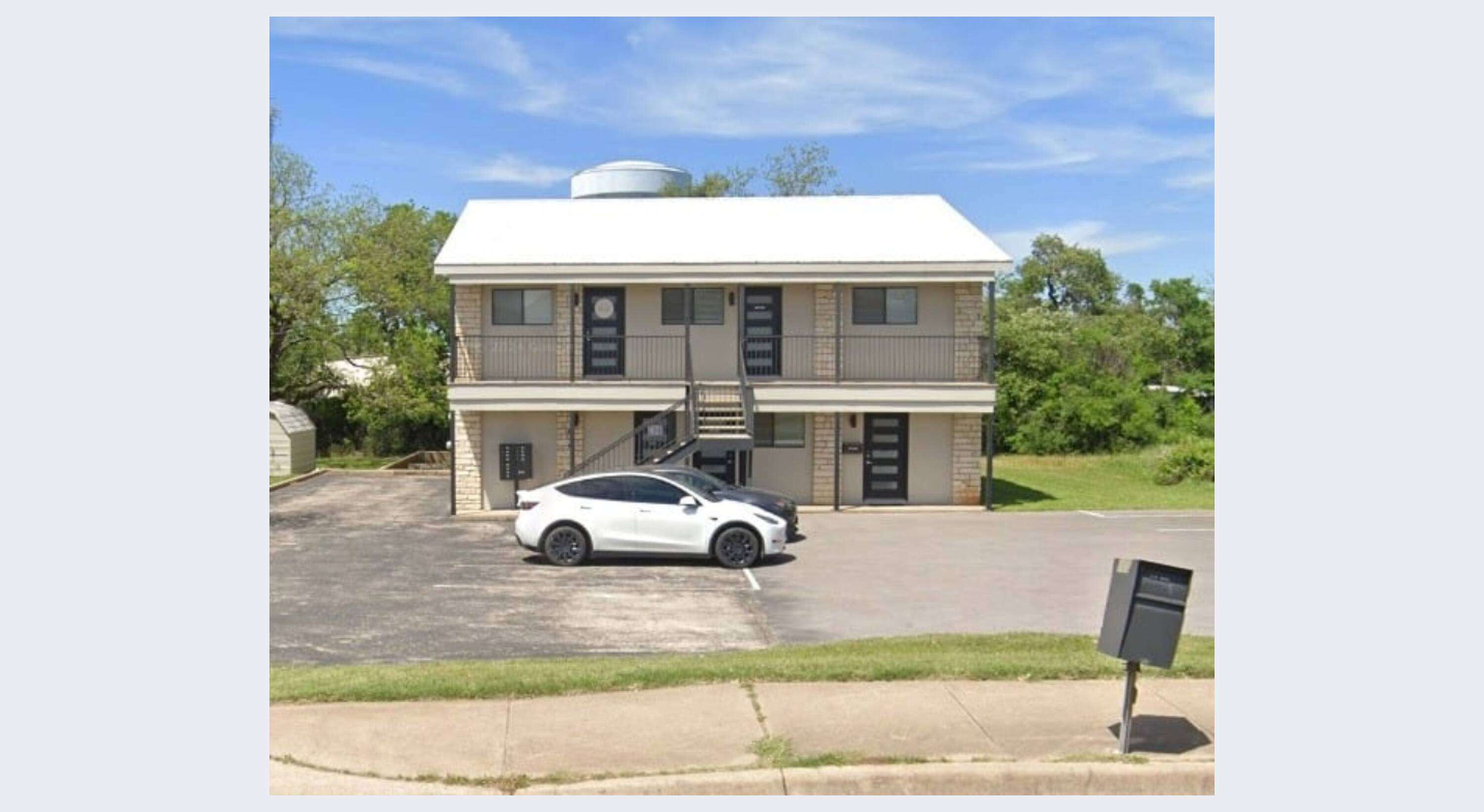 Modern two-story mixed-use building with surface parking and large windows in Austin, TX.