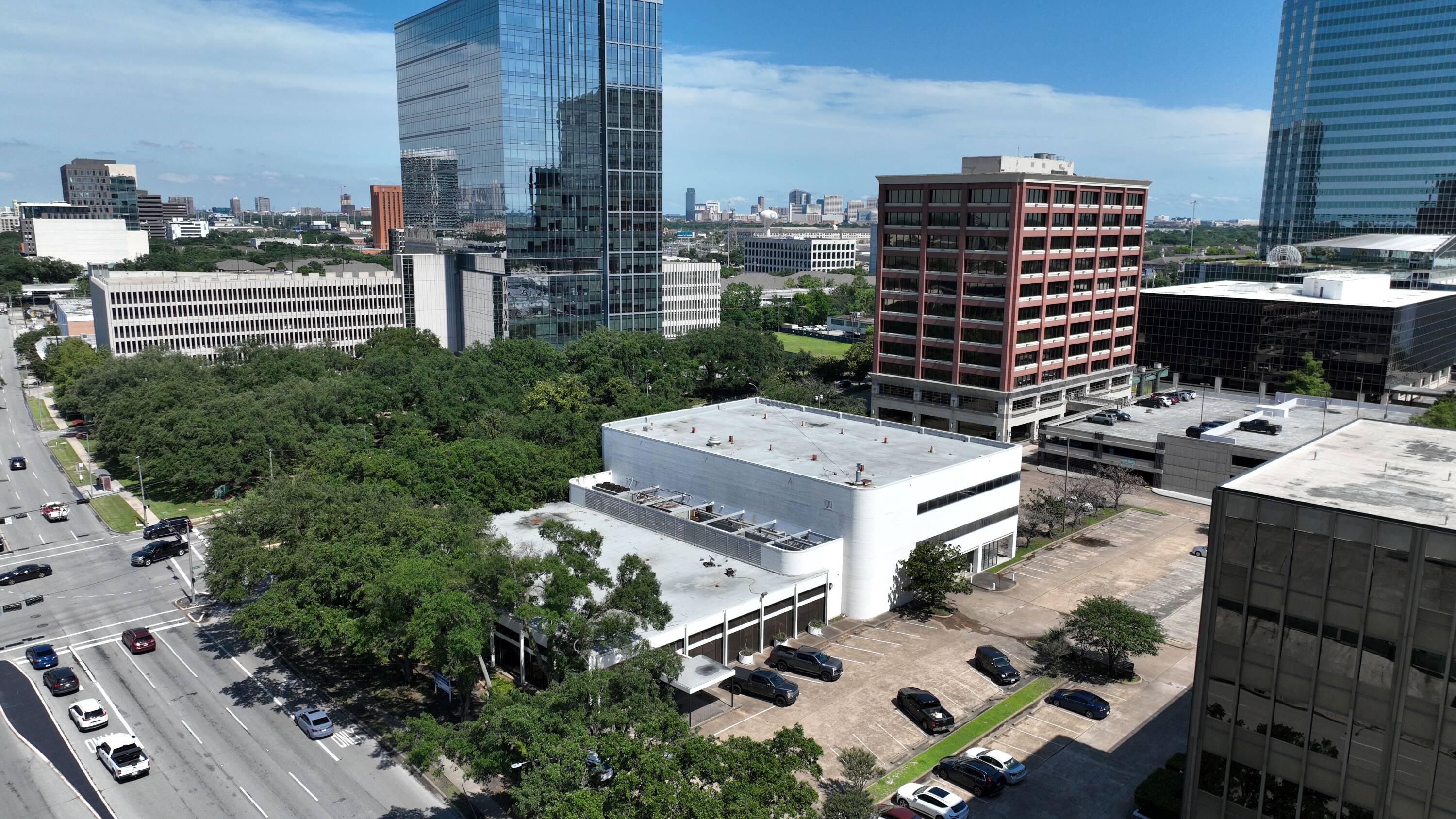 Aerial view of 3403 Richmond Ave, a mixed-use property in Houston with surrounding high-rise buildings and greenery.