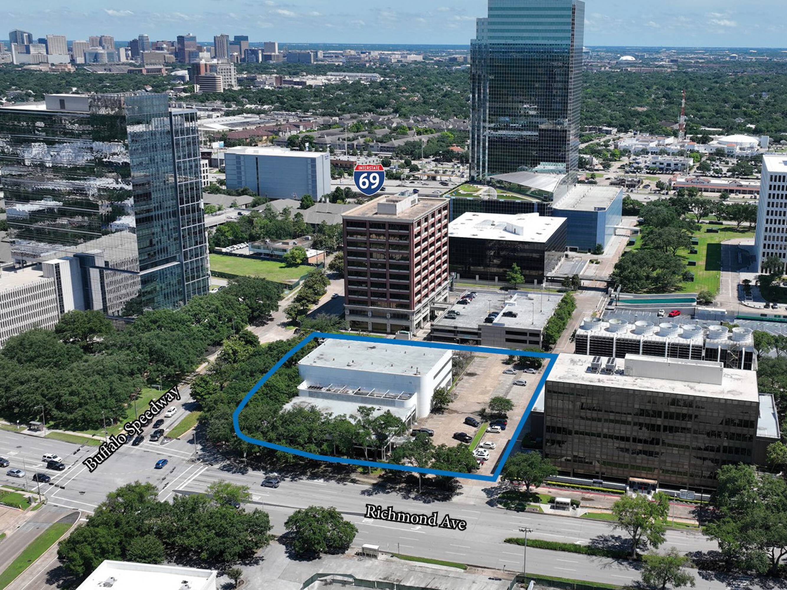 Aerial view of 3403 Richmond Ave., Houston, TX, showing a mixed-use property with surrounding parking and high-rise neighbors.