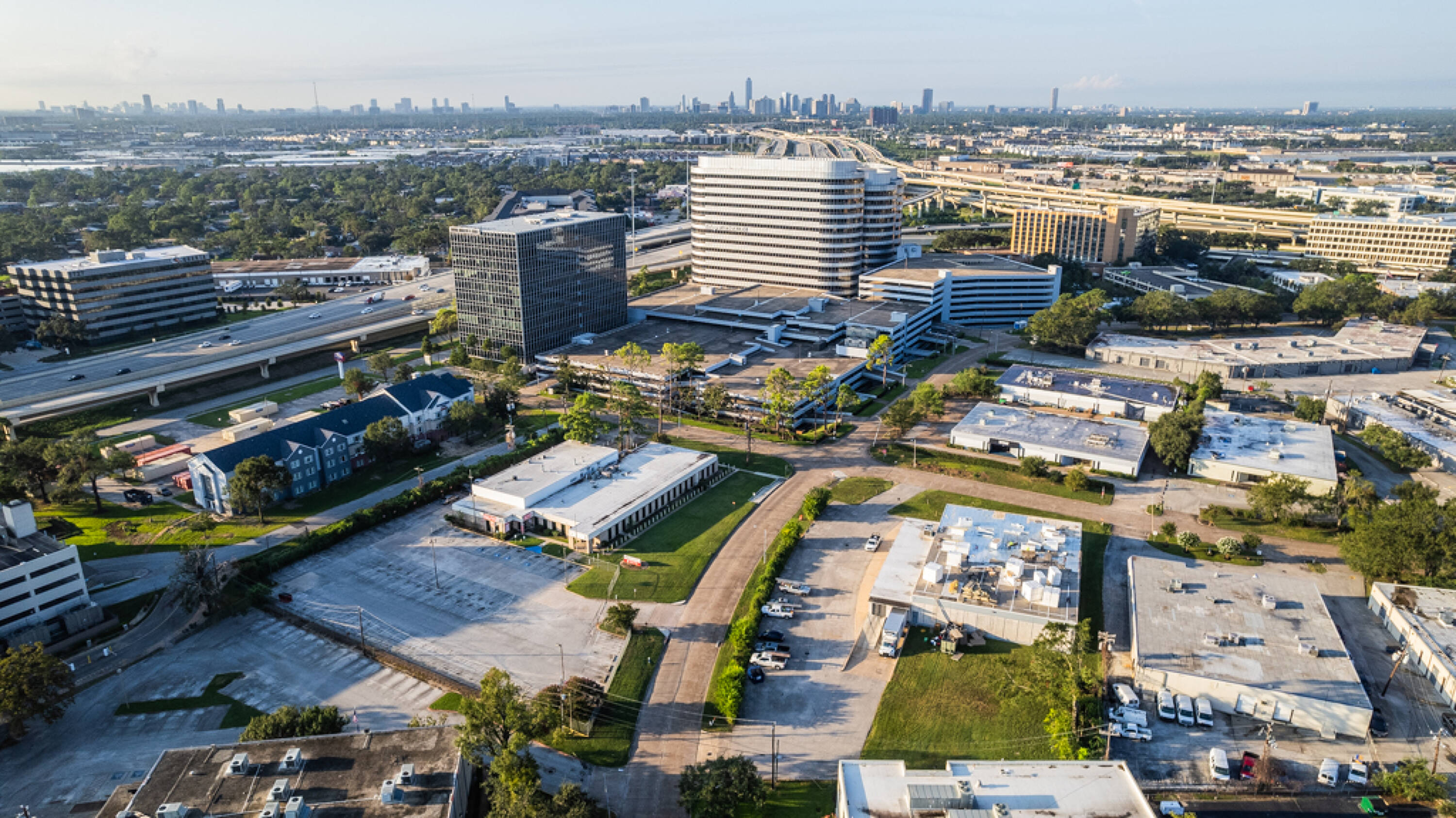 Aerial view of 2110 E Governors Circle, a modern office complex in Houston, TX with ample parking and green space.