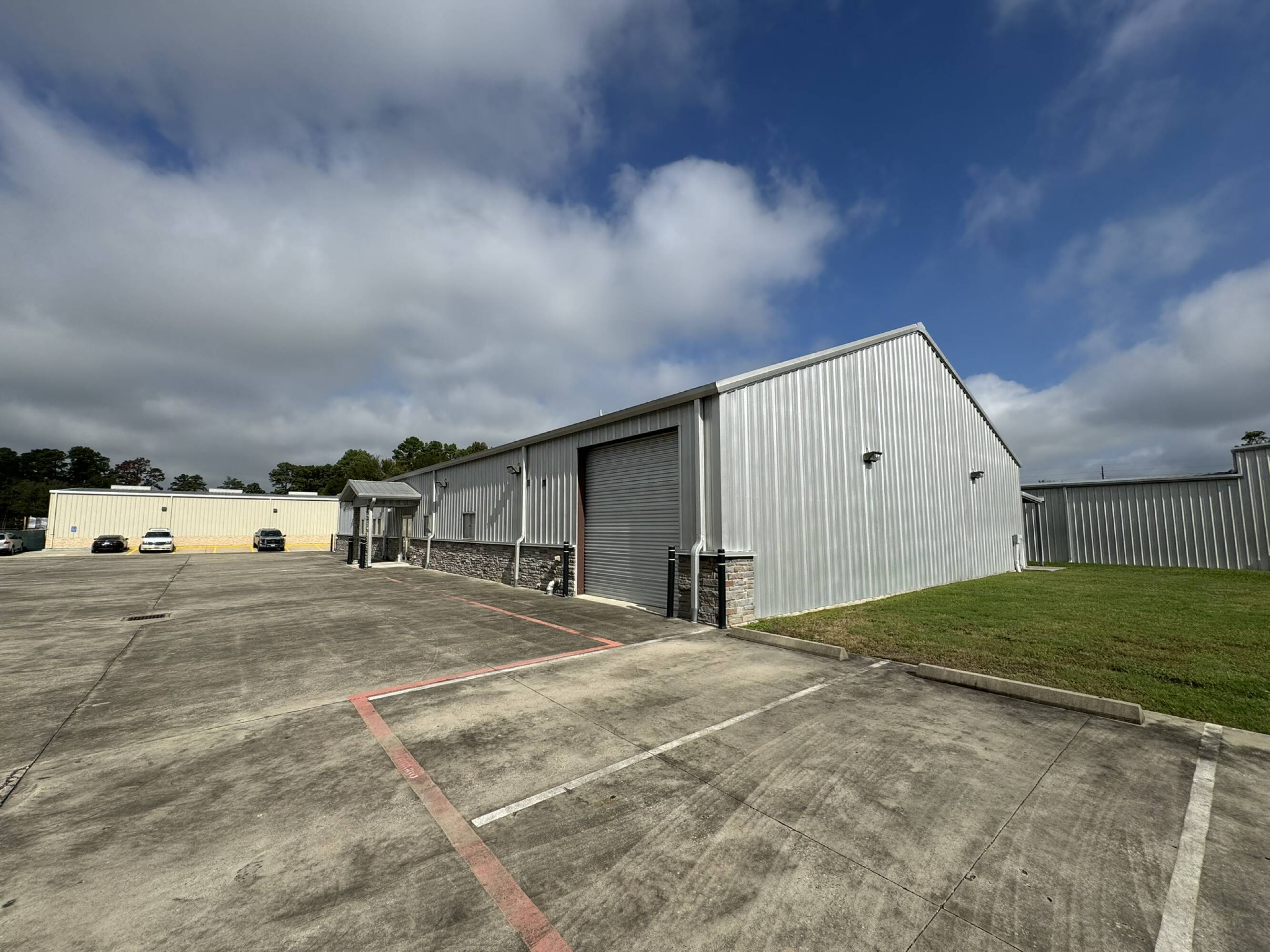 Exterior view of a metal industrial and office warehouse with ample parking and loading docks in Spring, TX.