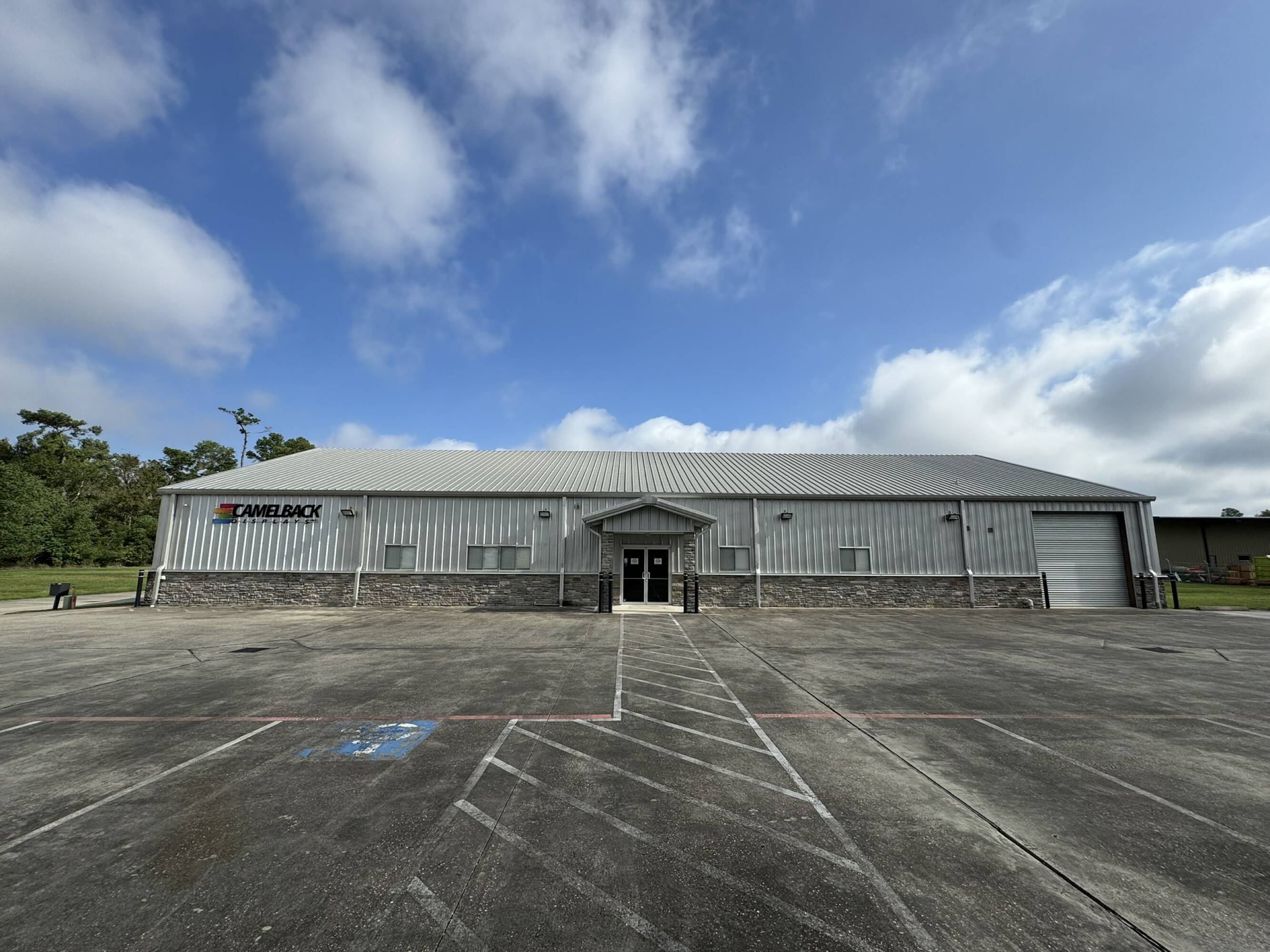 Front view of a modern office warehouse with ample parking and loading areas in Spring, TX.