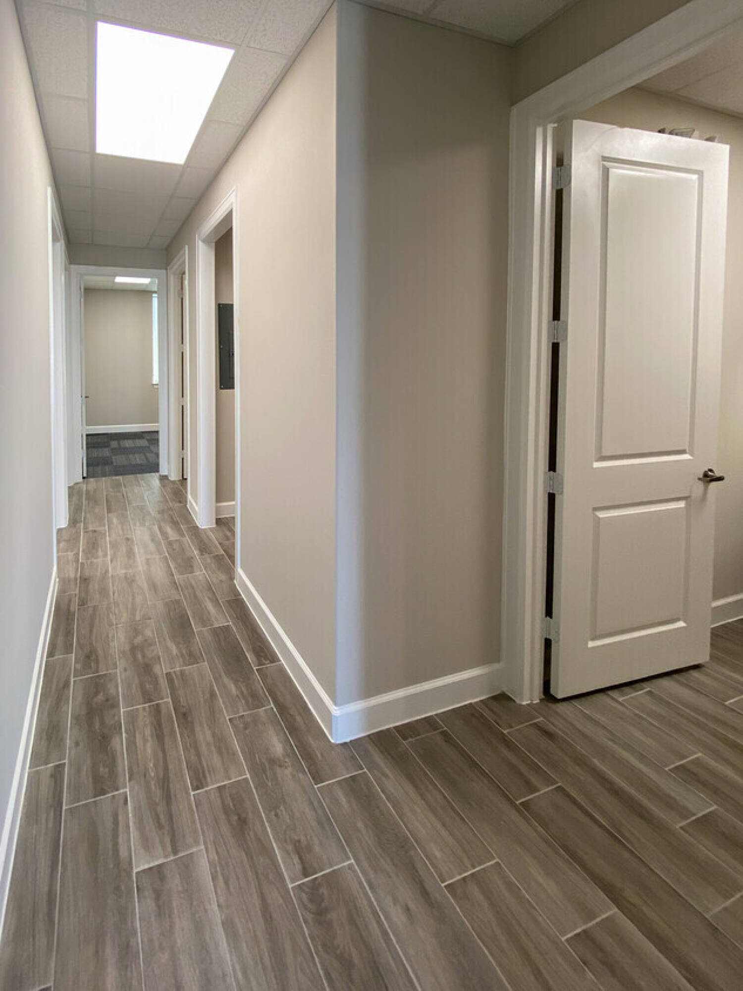 Interior hallway of Woodforest Medical Center - Building 4 with modern lighting and wood-look tile flooring.