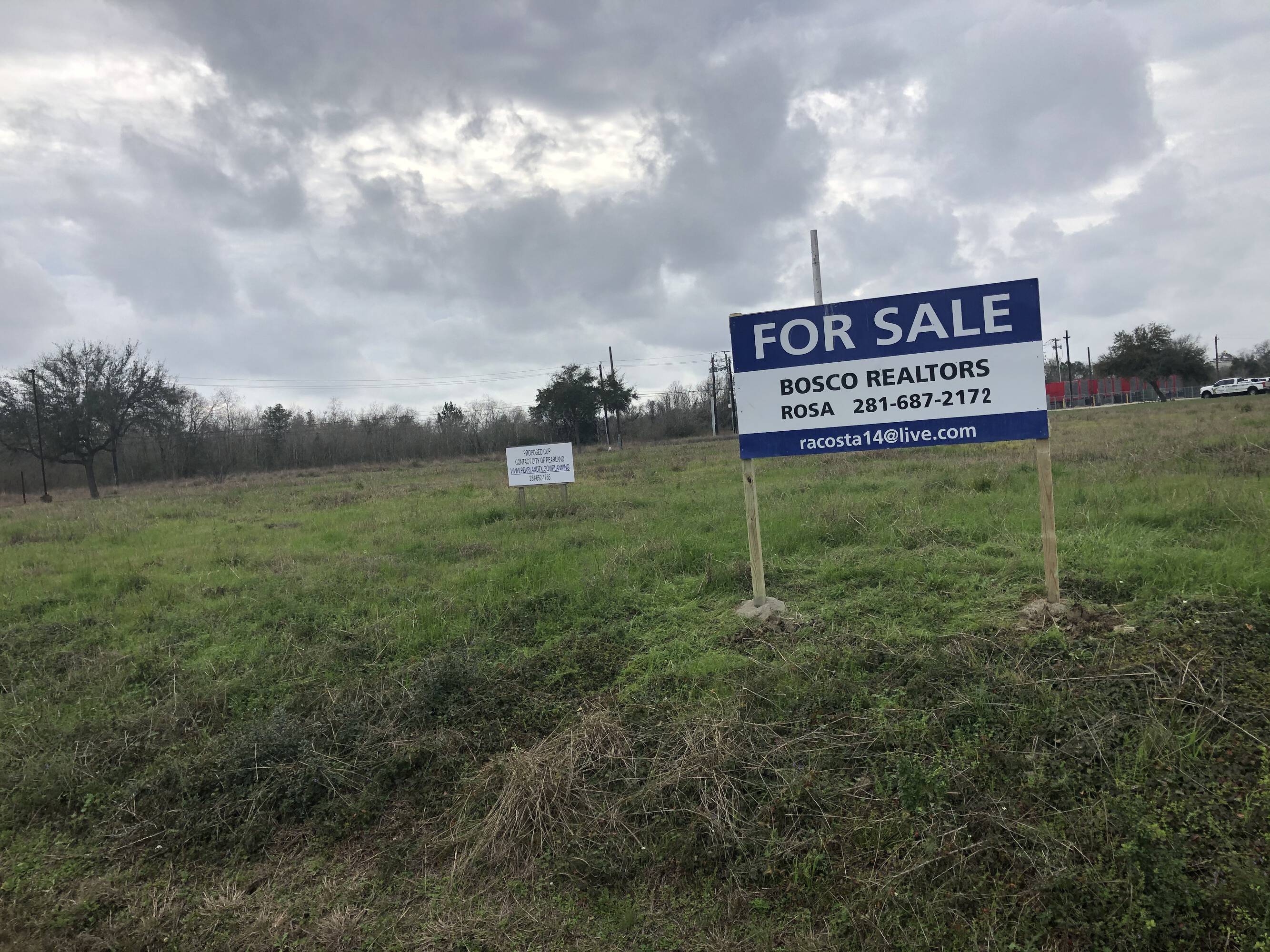 For sale sign on a vacant land parcel at 3200 Main St., Pearland, TX 77581.