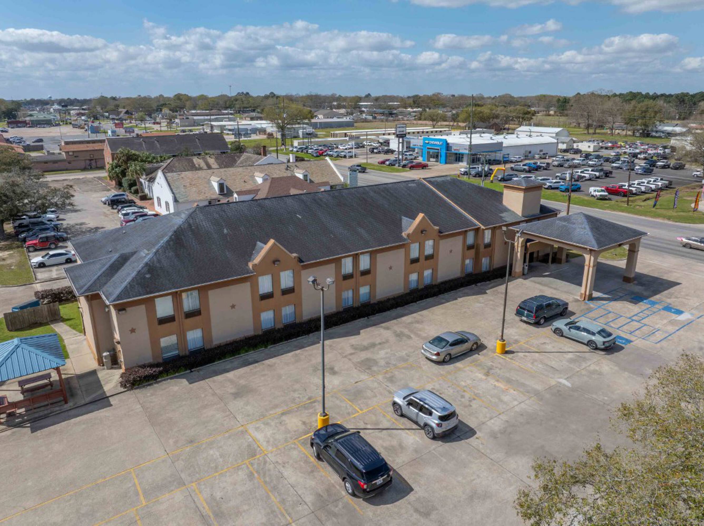 Aerial view of Days Inn & Suites by Wyndham Eunice with ample parking and surrounding commercial properties.
