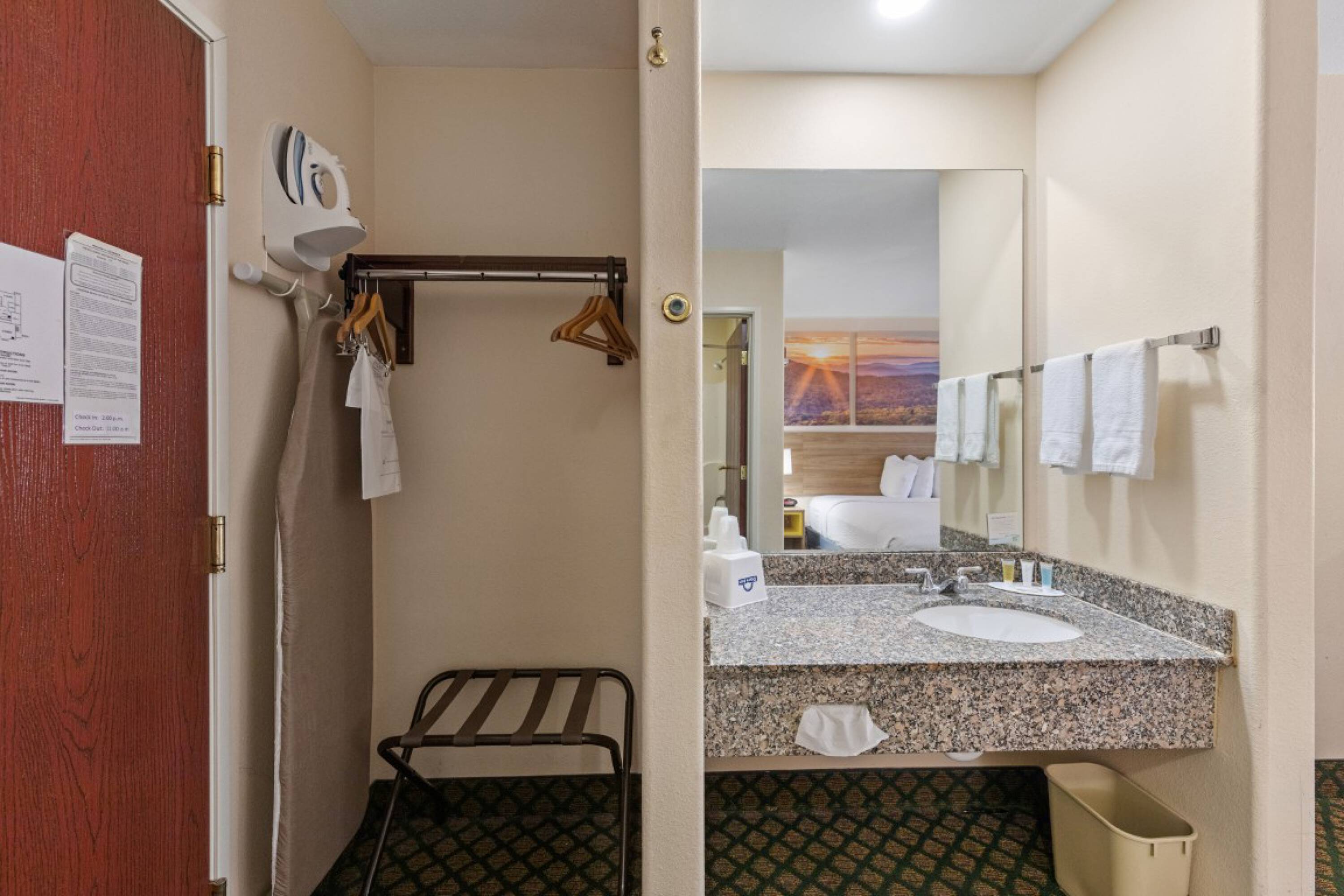 Interior view of a guest room at Days Inn & Suites by Wyndham Eunice, showing the bathroom and closet area.