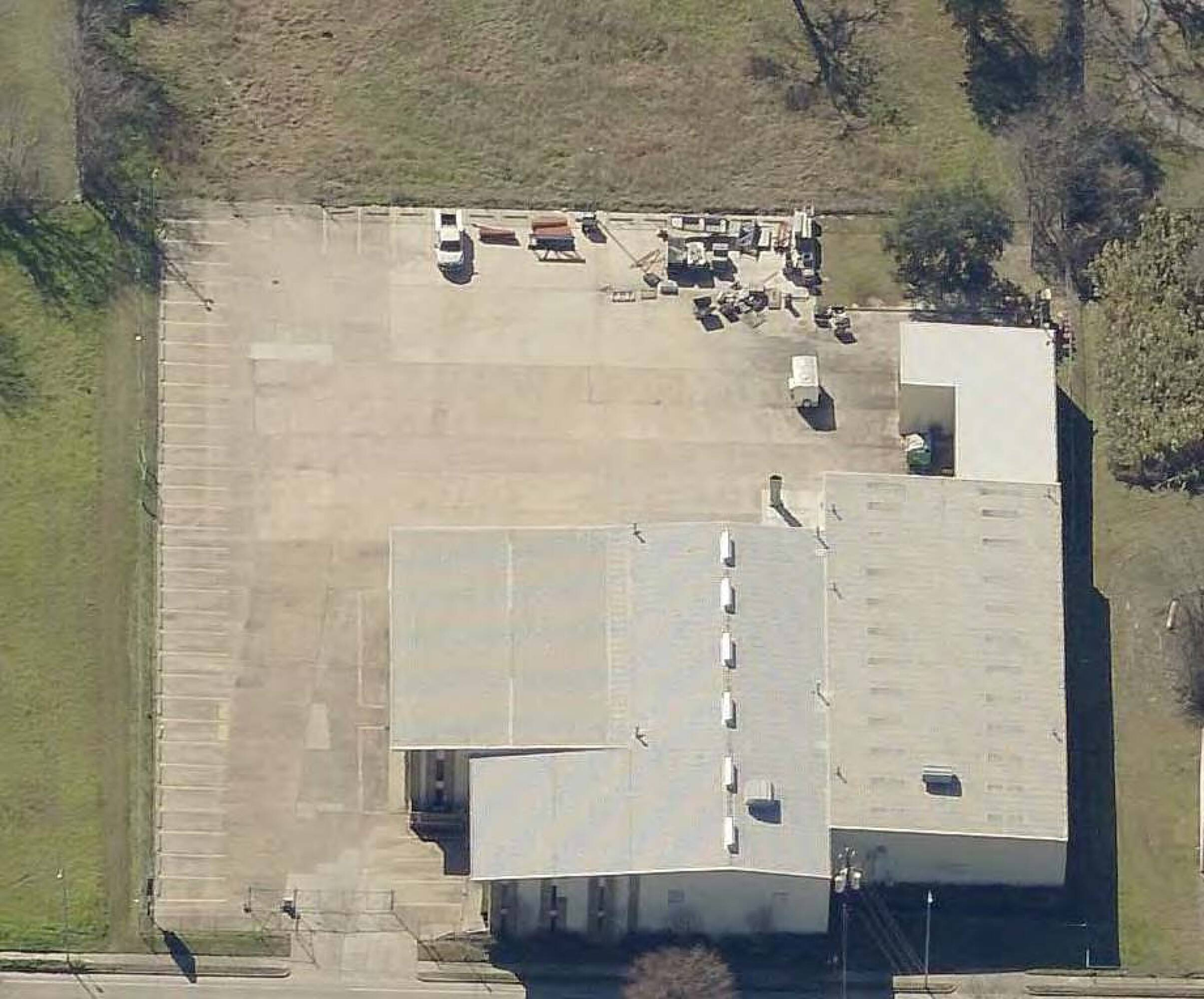 Aerial view of the industrial/office property at 4723 Pinemont Dr, Houston, TX 77092, showcasing parking lot and building layout.