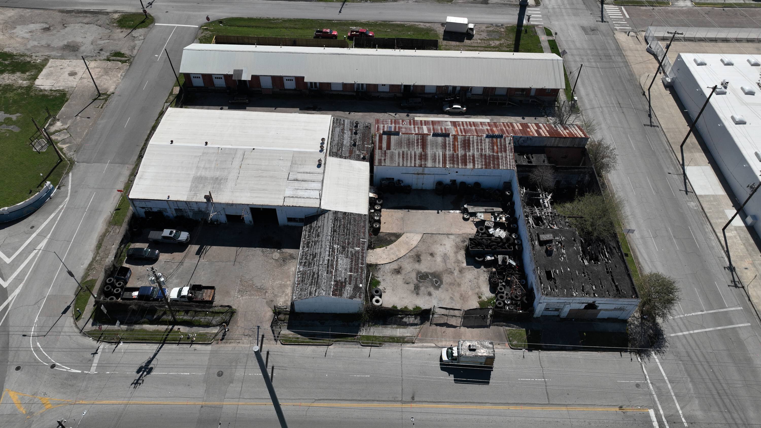 Aerial view of 215 St Emanuel & 2104 Franklin St, Houston, TX, showcasing industrial buildings with loading areas and parking.