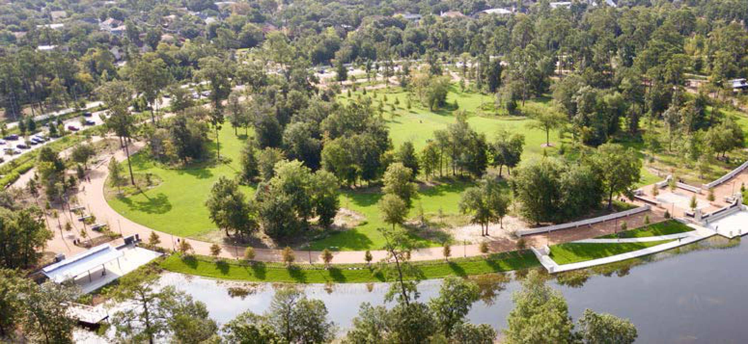 Aerial view of a large, open green space with a circular path and adjacent parking lot at 7701 Washington Avenue, Houston, TX.