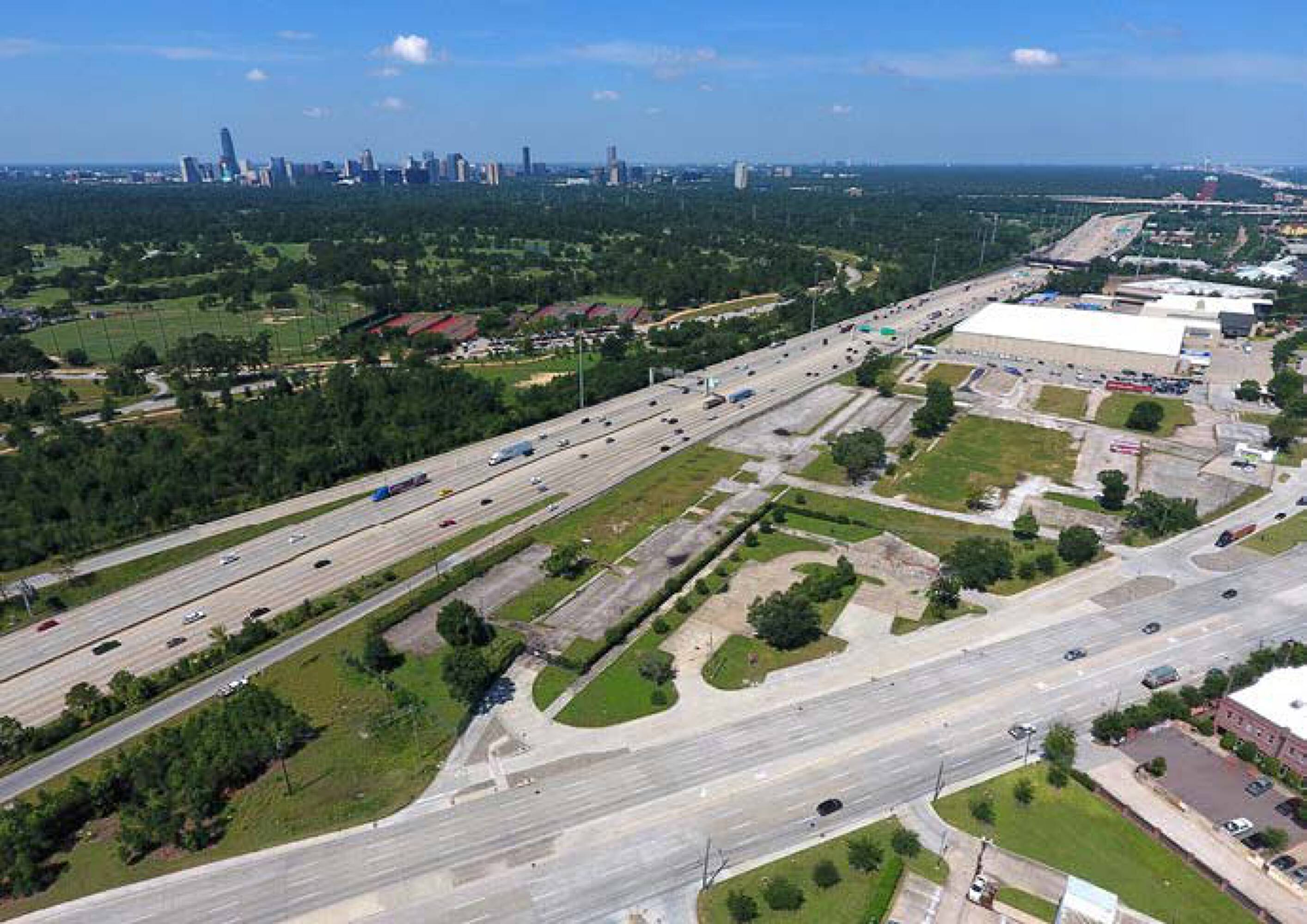 Aerial view of the vacant land at 7701 Washington Avenue, Houston, TX, showing surrounding roads and buildings.
