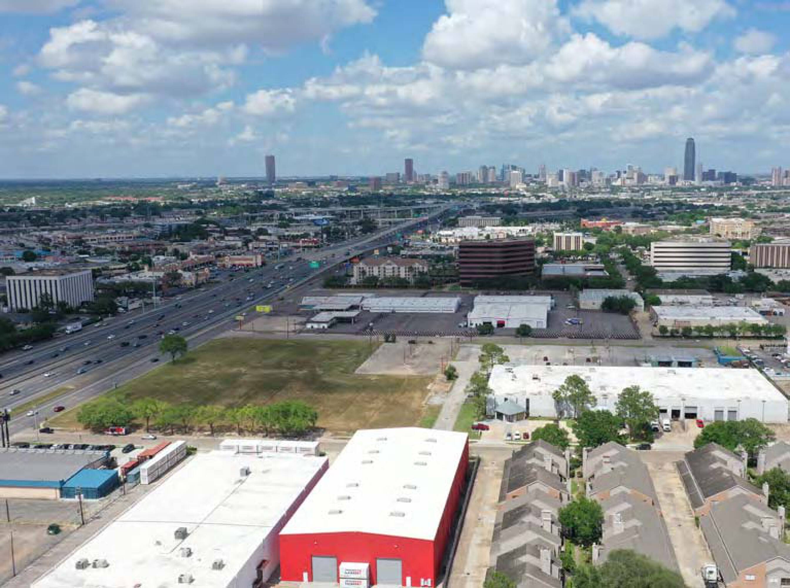 Aerial view of 6767 Southwest Fwy, Houston, TX, showing vacant land with surrounding commercial and residential buildings.