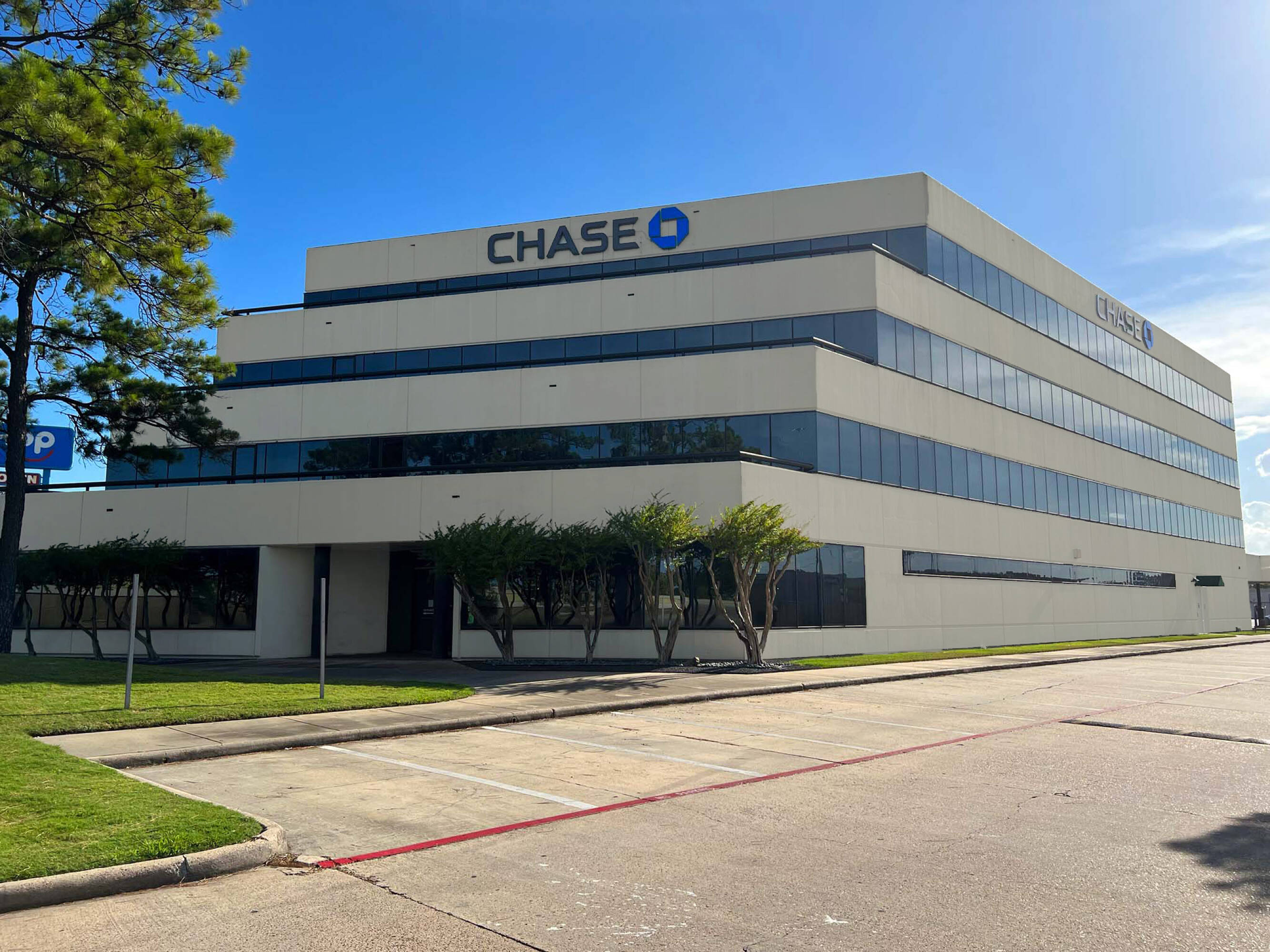 Four-story Chase Bank Office Building with large windows and surface parking in Humble, TX.