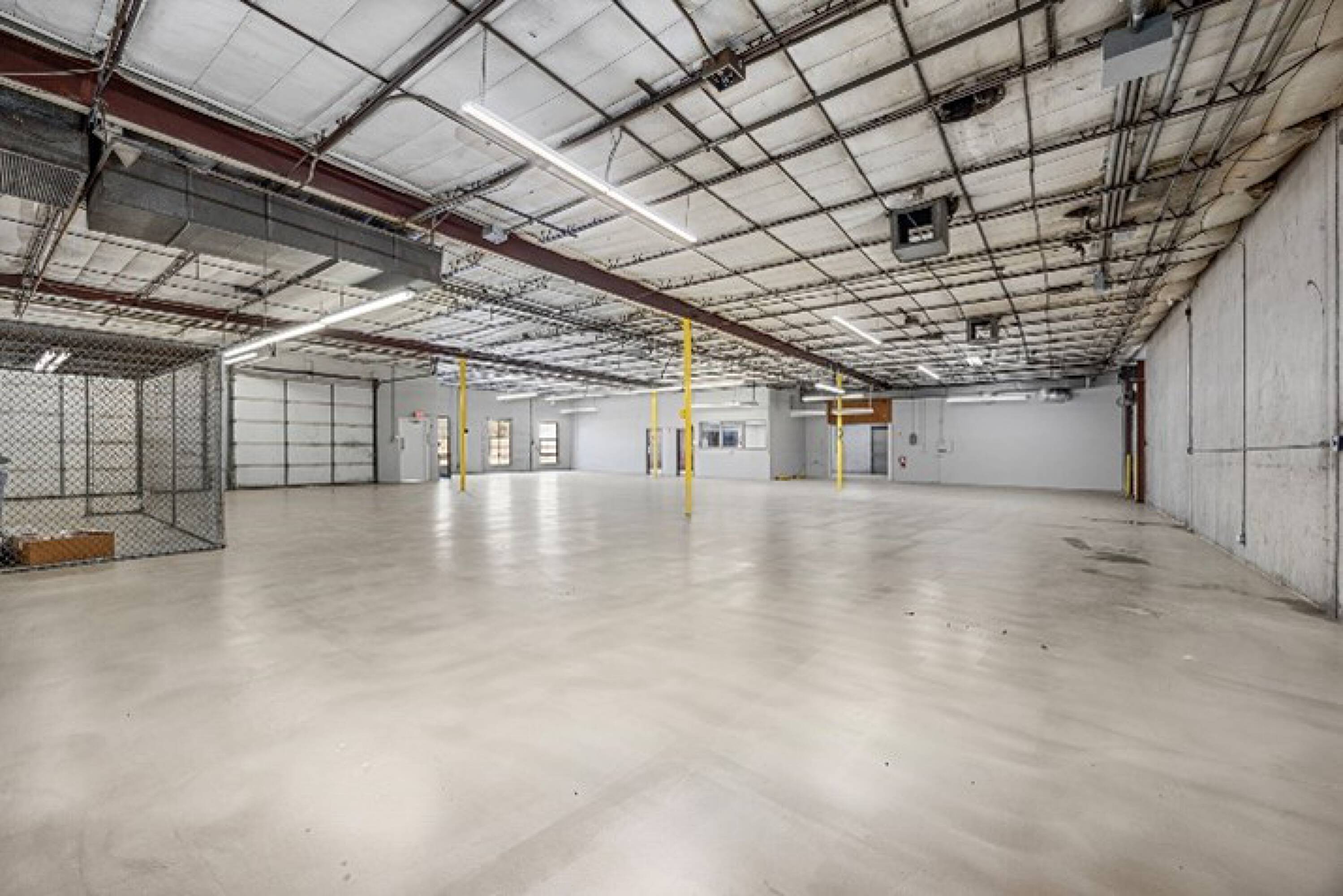 Spacious industrial warehouse with high ceilings, ample lighting, and large loading doors at 6880 Wynnwood Lane, Houston, TX.