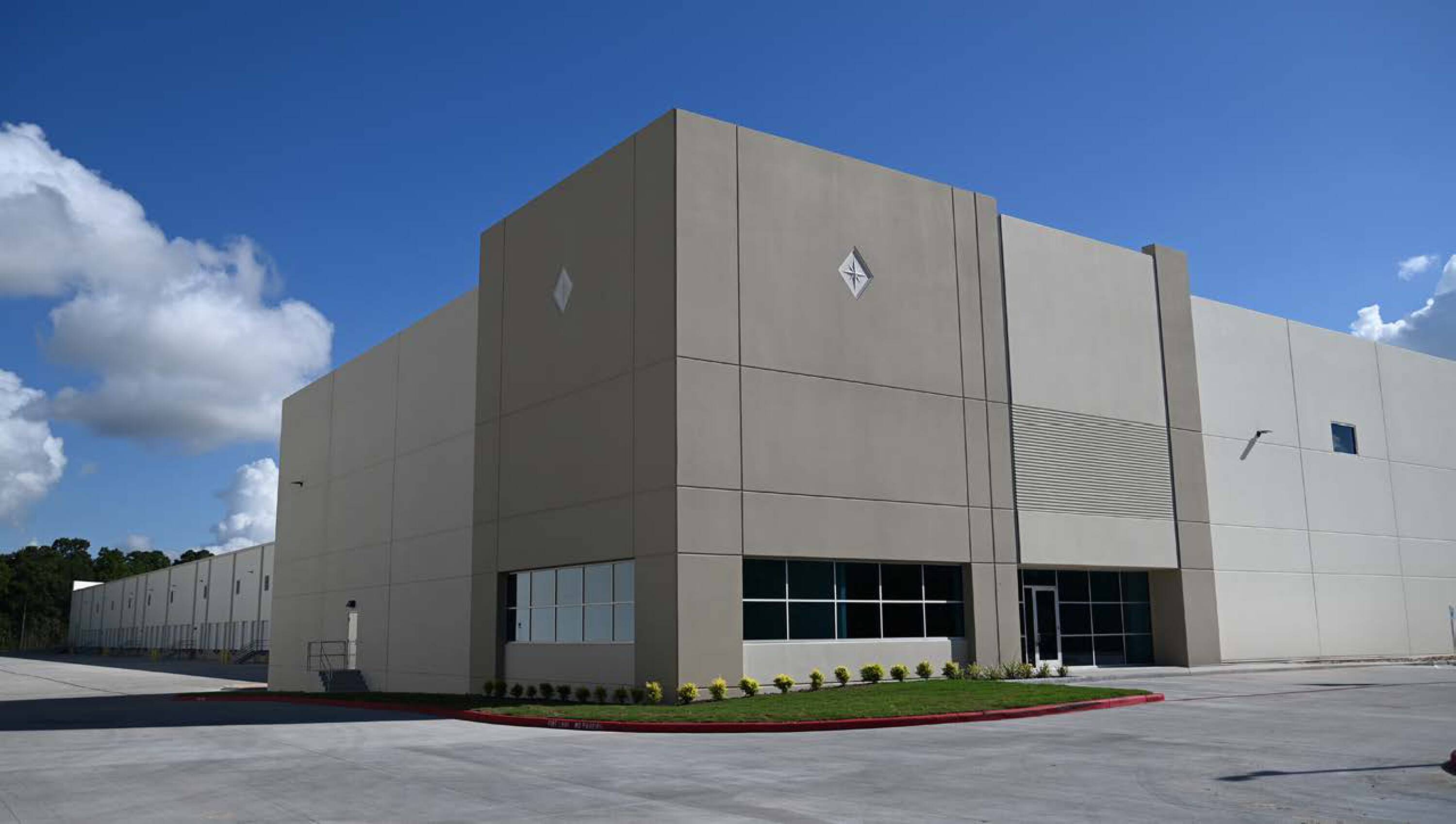 Modern industrial building with large windows and landscaped entrance at PortNorth 59 Industrial Park.