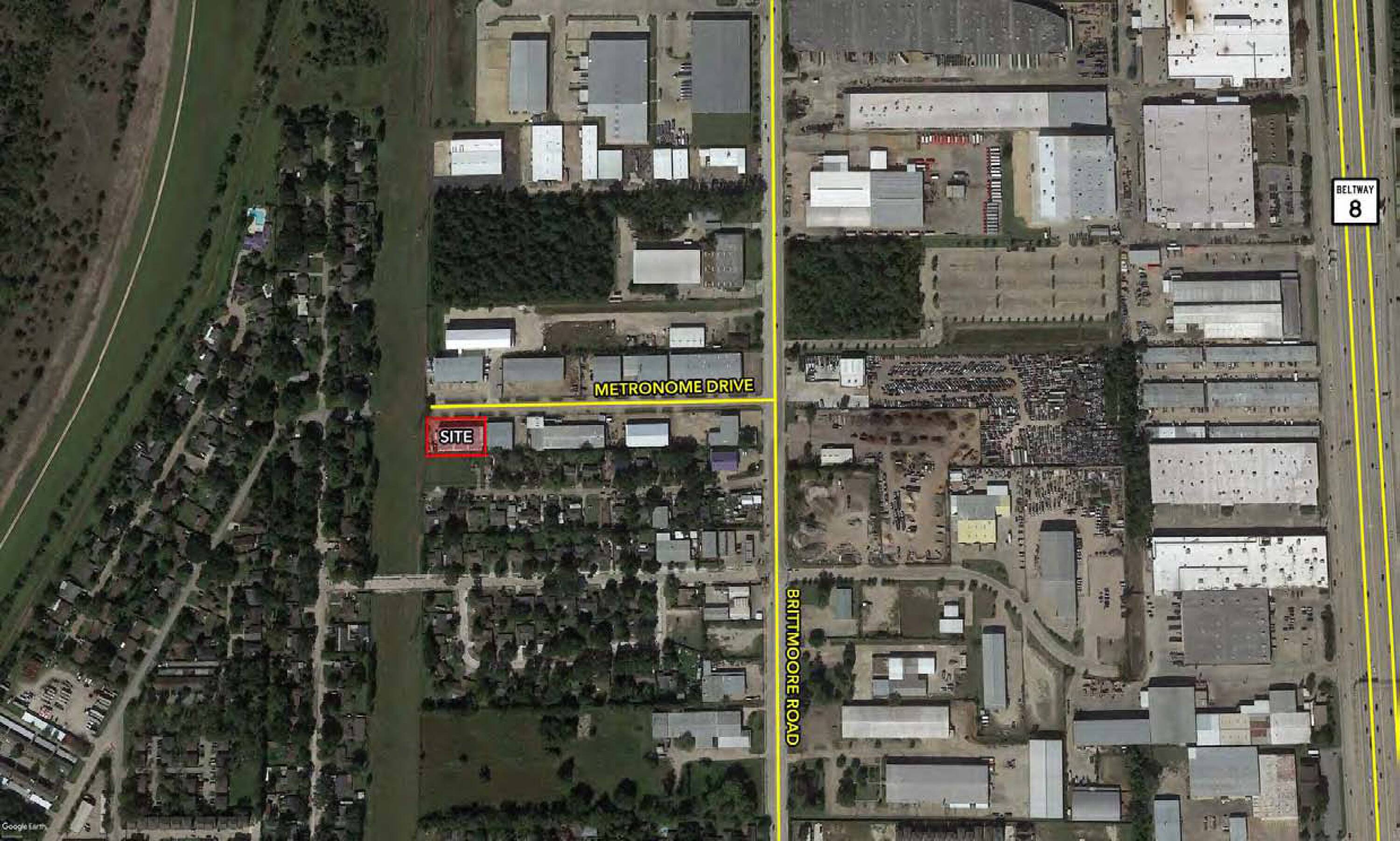 Aerial view of an industrial property with ample parking and loading areas, surrounded by other commercial buildings.