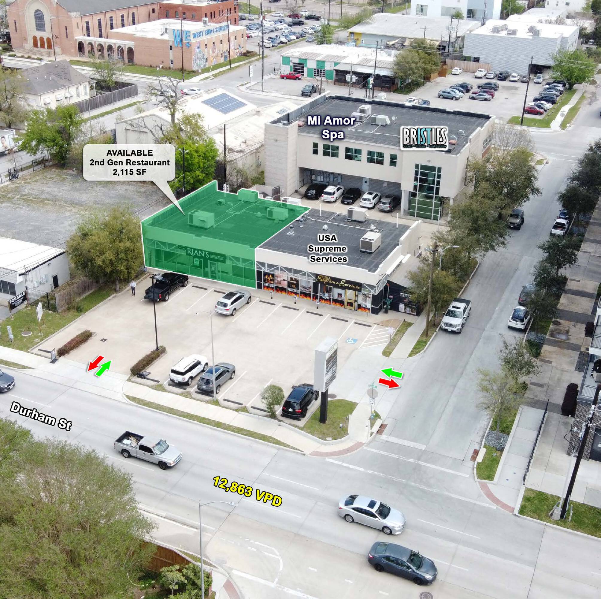 Aerial view of a commercial property with retail tenants and ample parking in an urban setting.