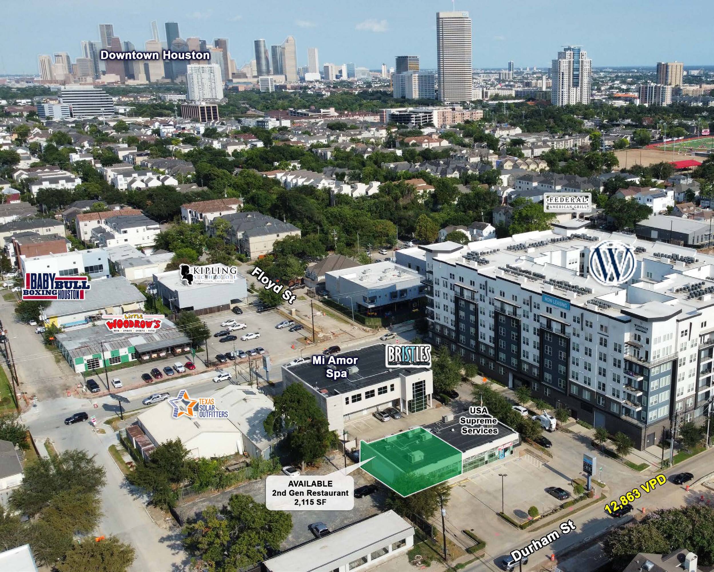 Aerial view of a modern commercial building in downtown Houston with surrounding businesses and cityscape.