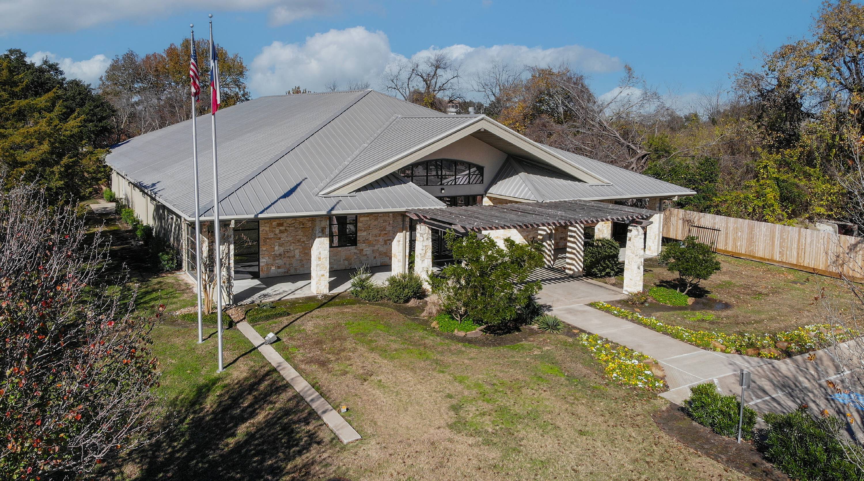 Aerial view of a single-tenant office building with stone facade and ample parking at 6950 W 43rd St, Houston, TX.