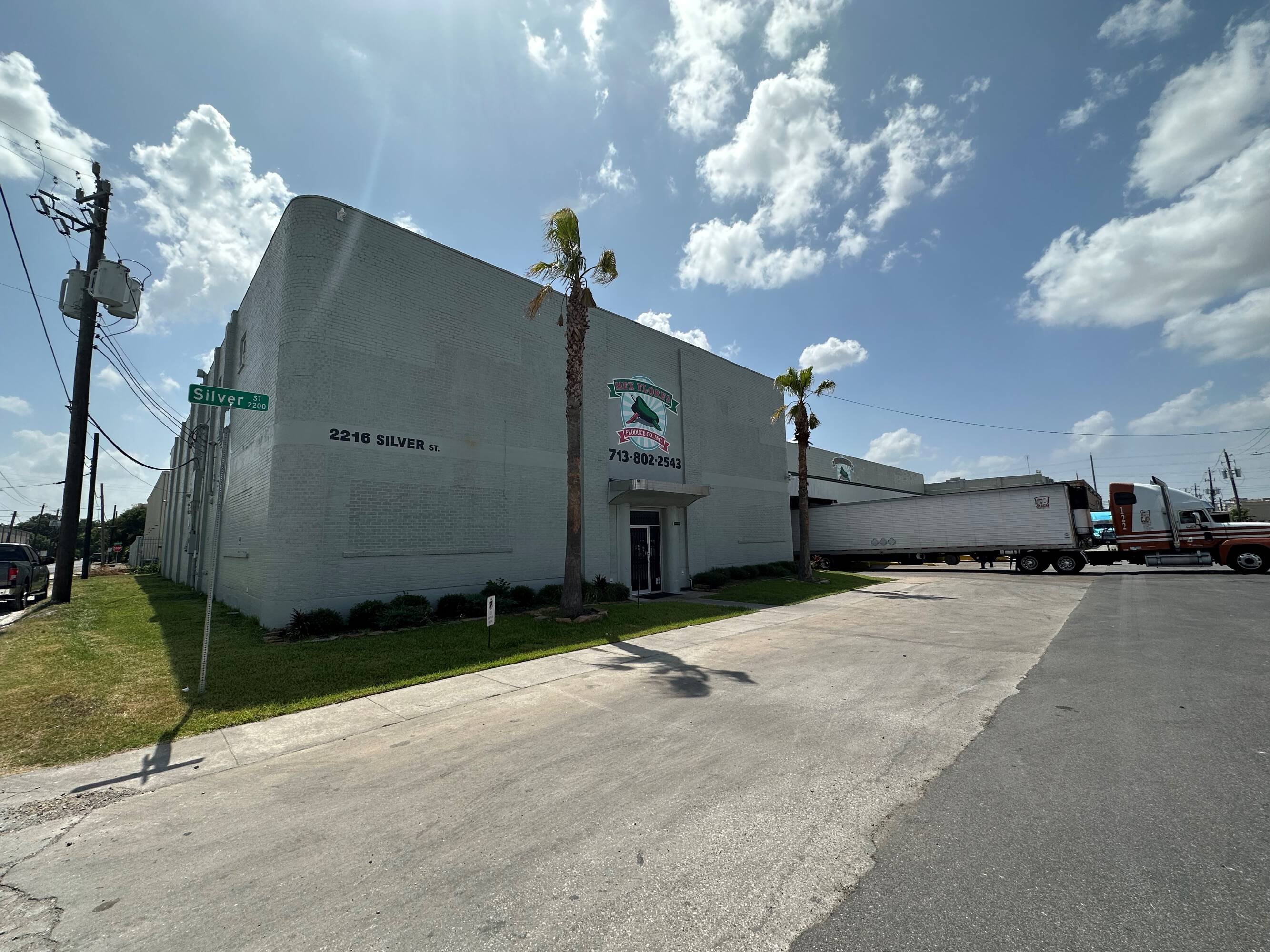 Exterior view of 2216 Silver Street, Houston, TX, featuring a concrete building with large windows and a loading dock.