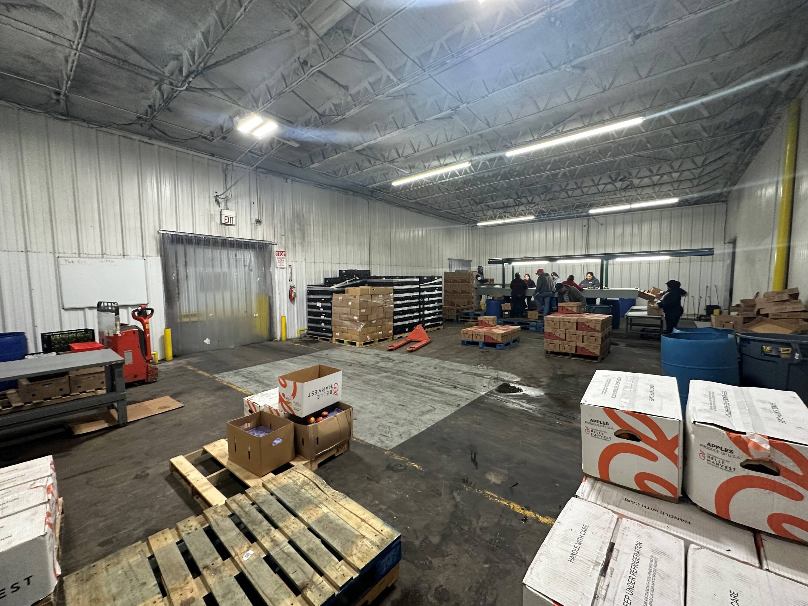 Interior of a well-lit industrial warehouse with high ceilings and organized storage areas.
