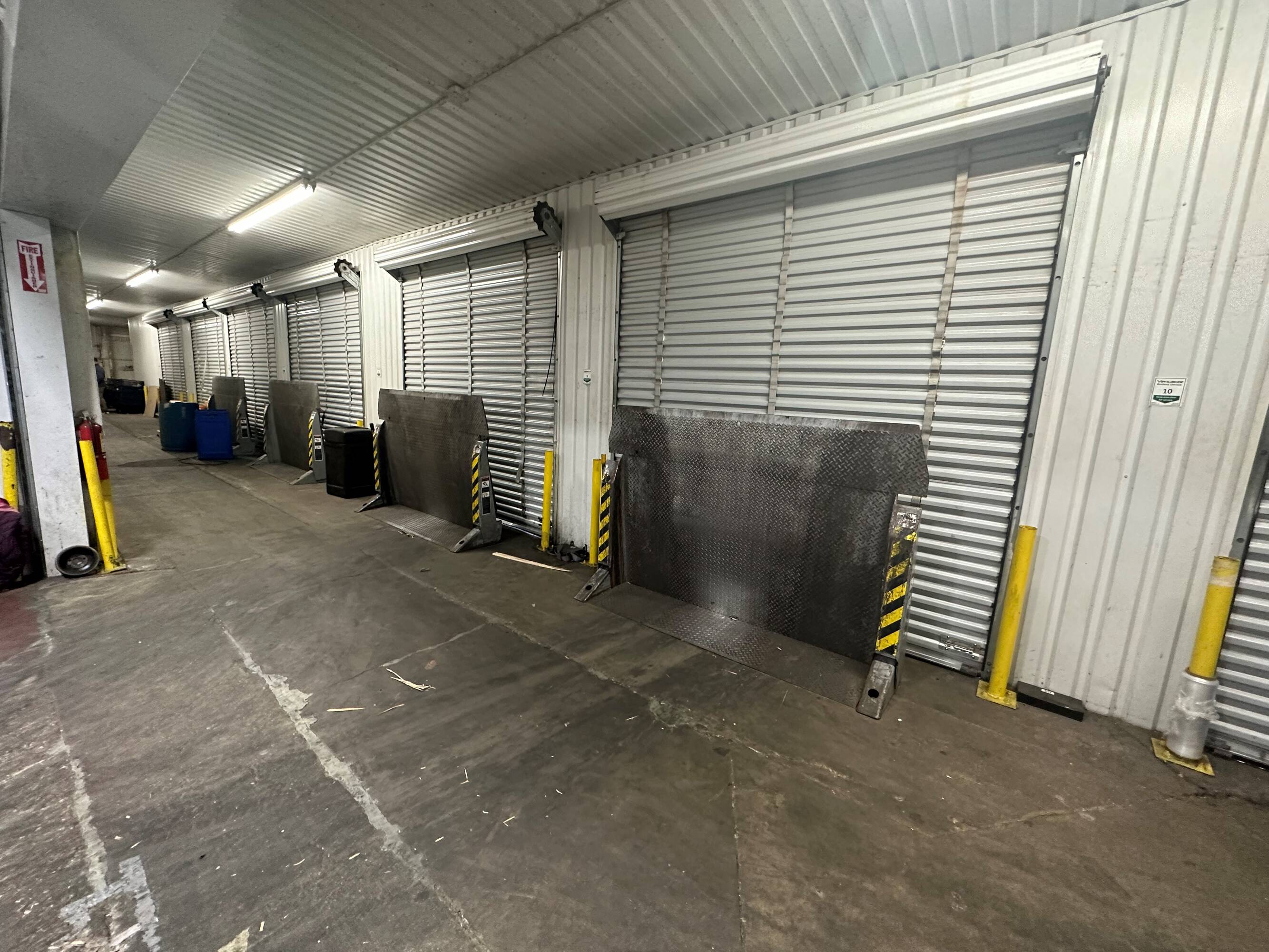 Multiple loading docks with overhead doors in a well-lit industrial facility.