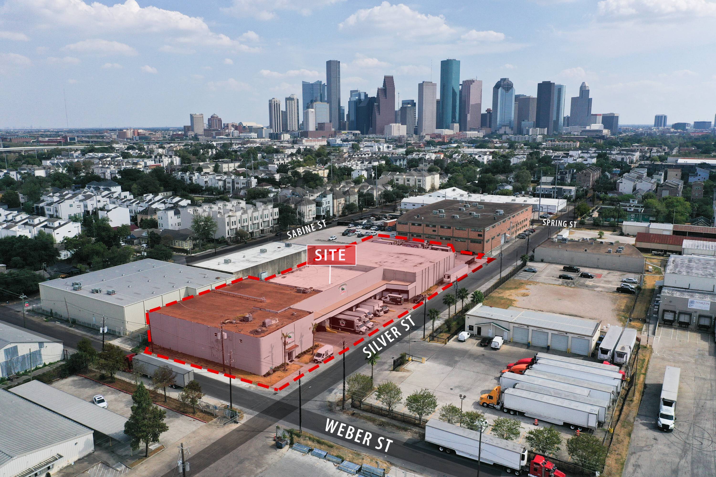 Aerial view of 2216 Silver Street, Houston, TX, showcasing the property's layout, parking, and surrounding urban environment.