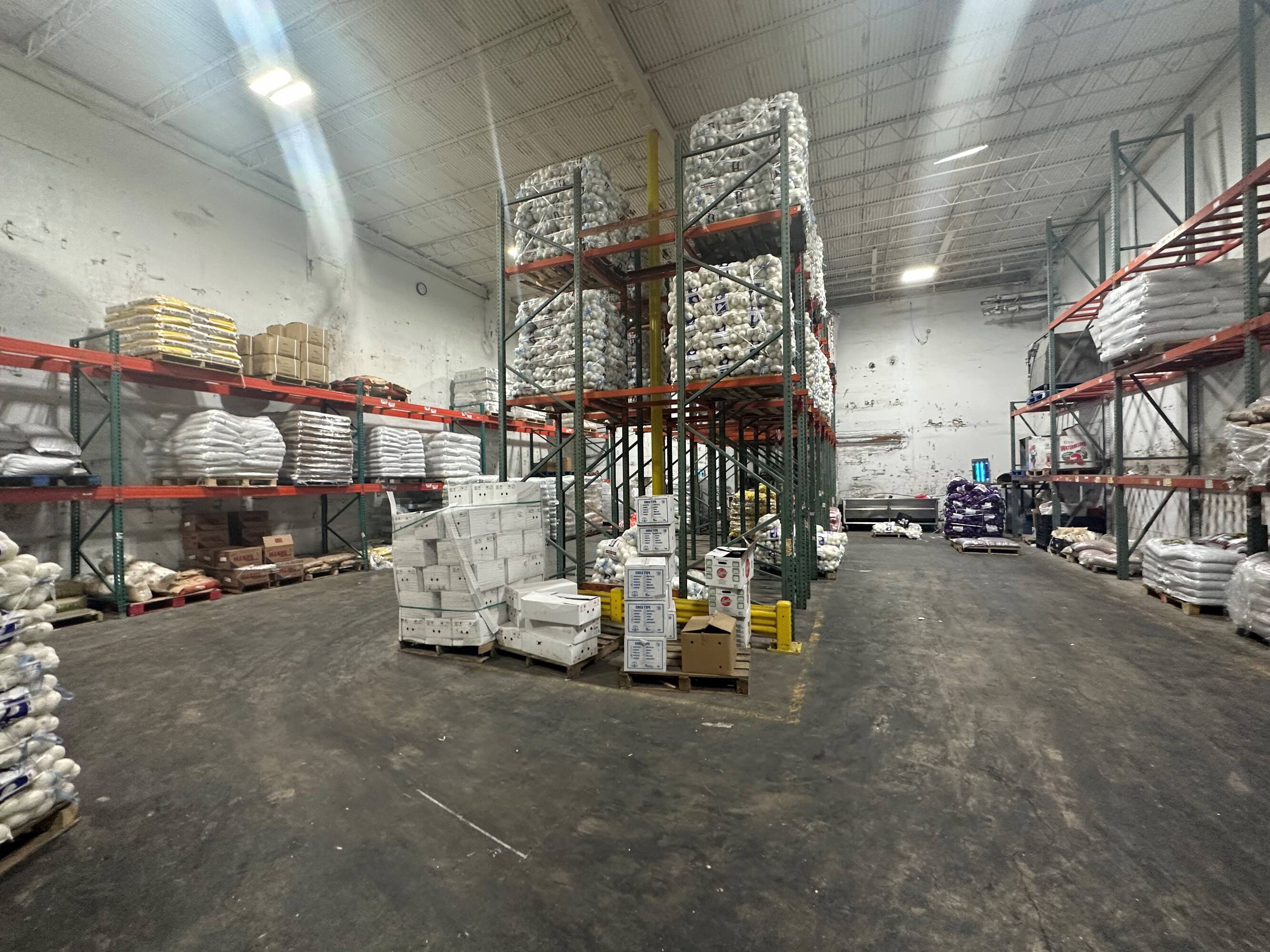 Interior of an industrial warehouse at 2216 Silver Street, Houston, TX, featuring high ceilings, organized shelving, and ample lighting.
