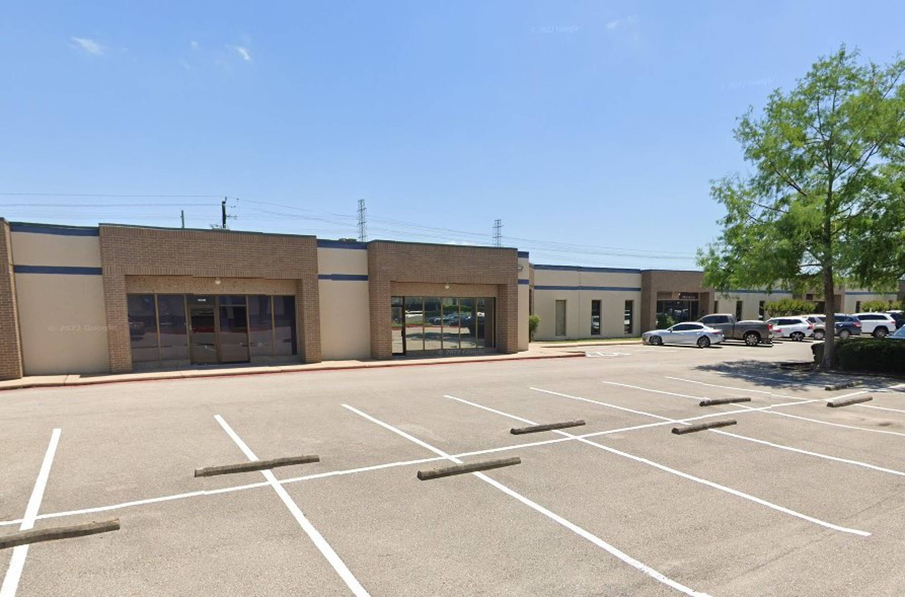 Front view of a single-story industrial building with ample parking and modern design at 1010-1066 Hercules Ave, Houston, TX.