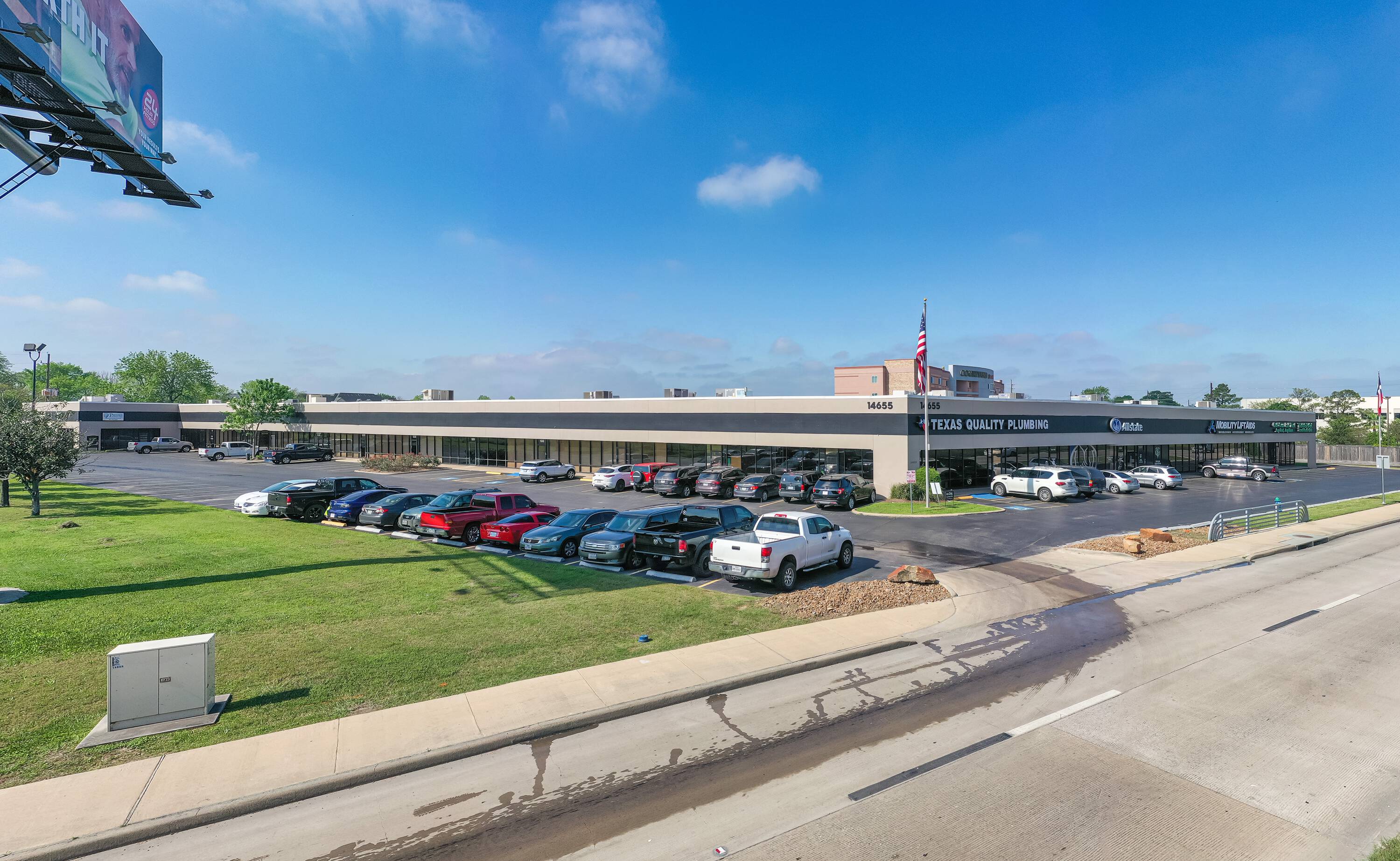 Exterior view of Northwest Gessner Center, a single-story office and industrial building with ample parking and loading areas in Houston, TX.