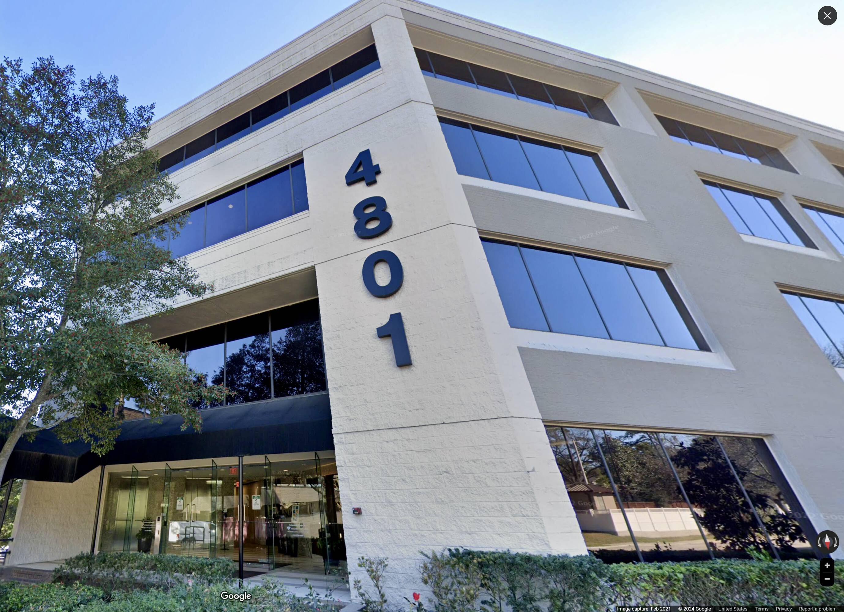 Modern office building with large windows and address 4801 prominently displayed.