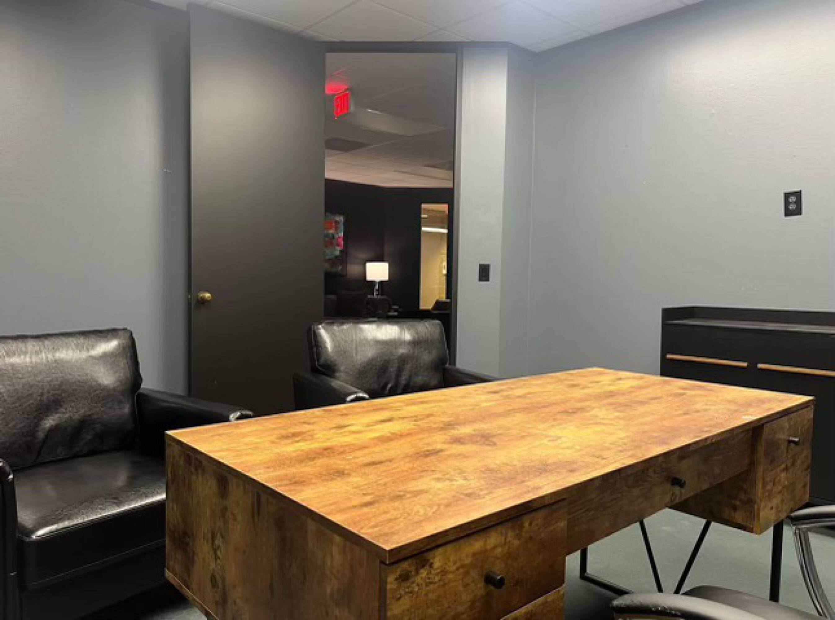 Interior view of a modern office space with a wooden desk and leather chairs in the Law Office of Sean Buckley.