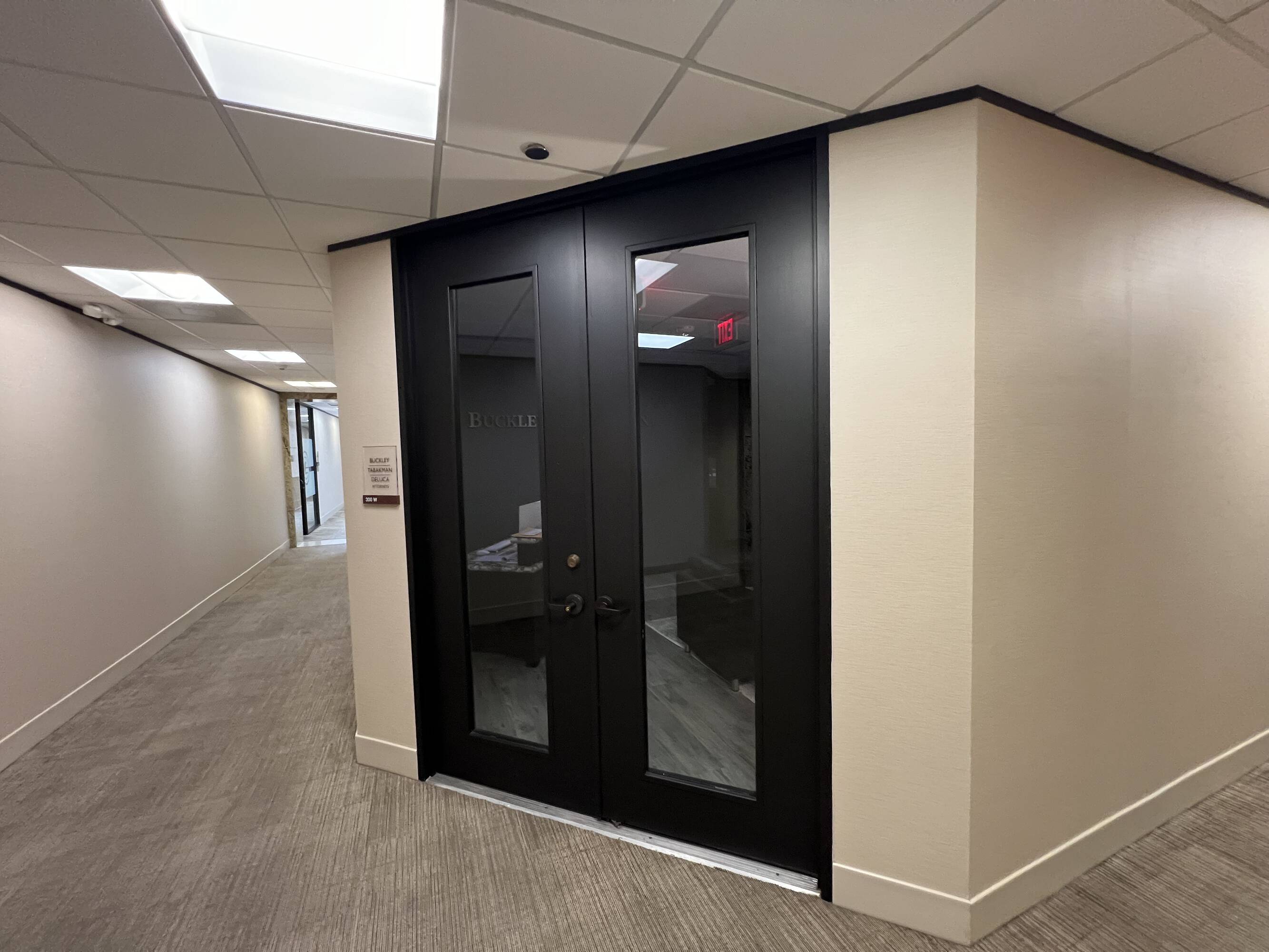 Entrance to the Law Office of Sean Buckley at Woodway Center with a secure glass door and carpeted hallway.