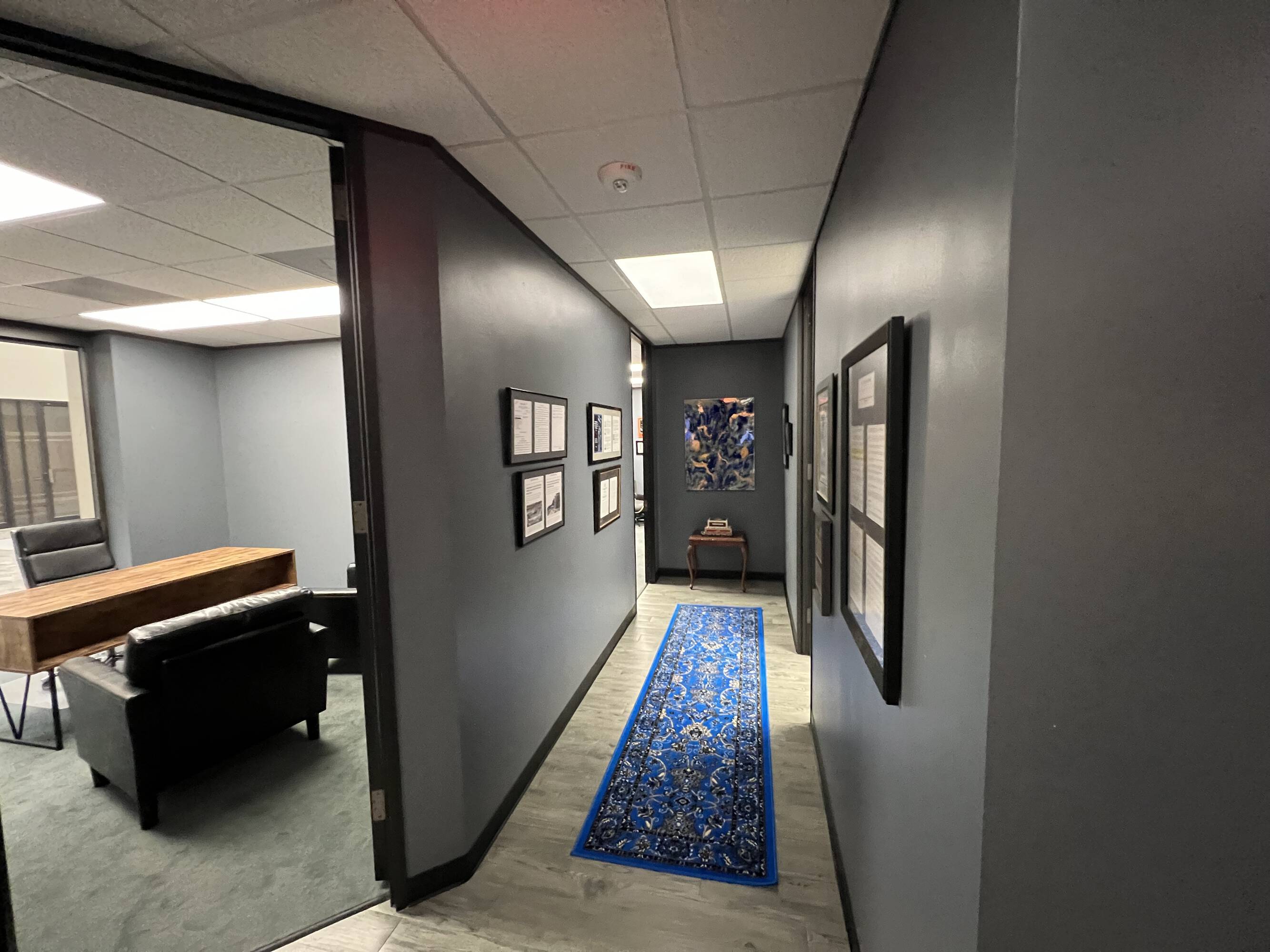 Hallway of the Law Office of Sean Buckley with modern decor, artwork, and blue accent rug.