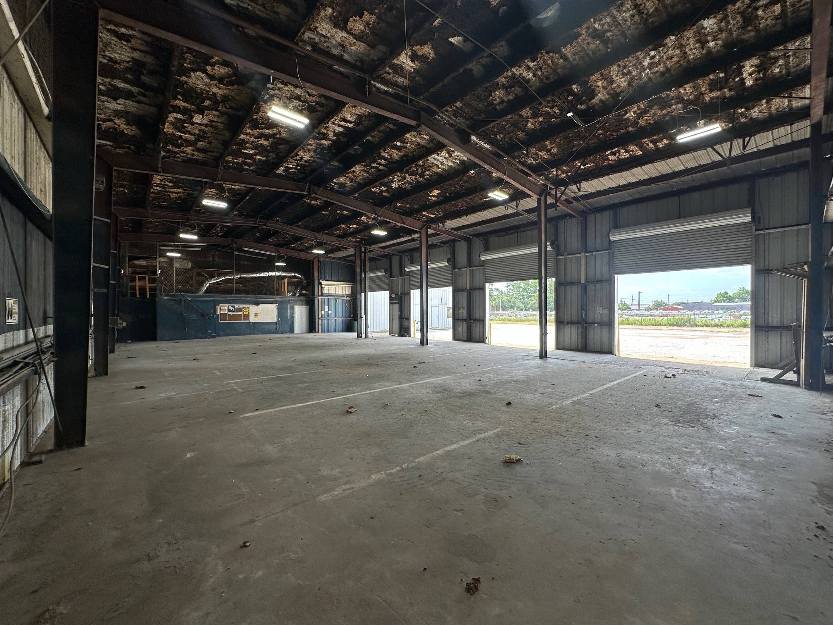 Spacious industrial warehouse with high ceilings, large overhead doors, and high bay lighting at Brittmoore Business Park.