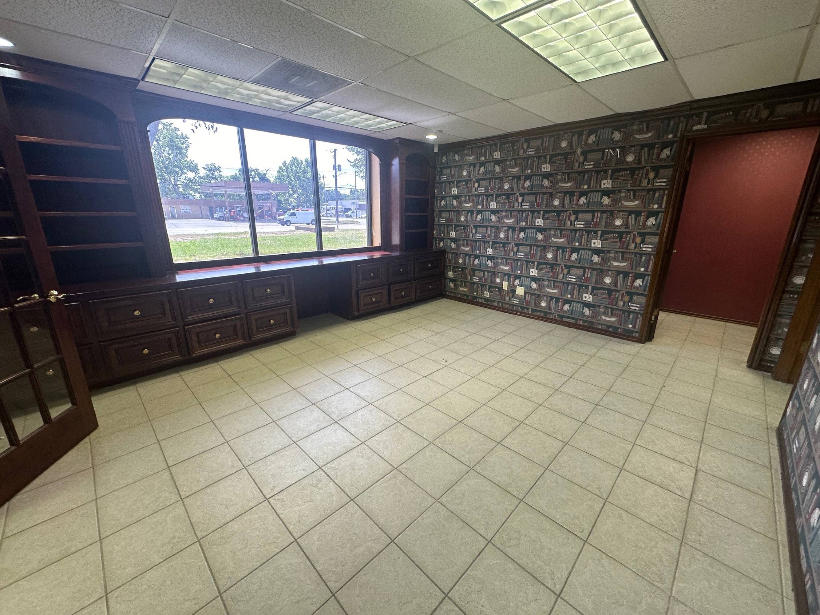 Interior view of an office space at Brittmoore Business Park with large windows, brick wall, and built-in cabinetry.