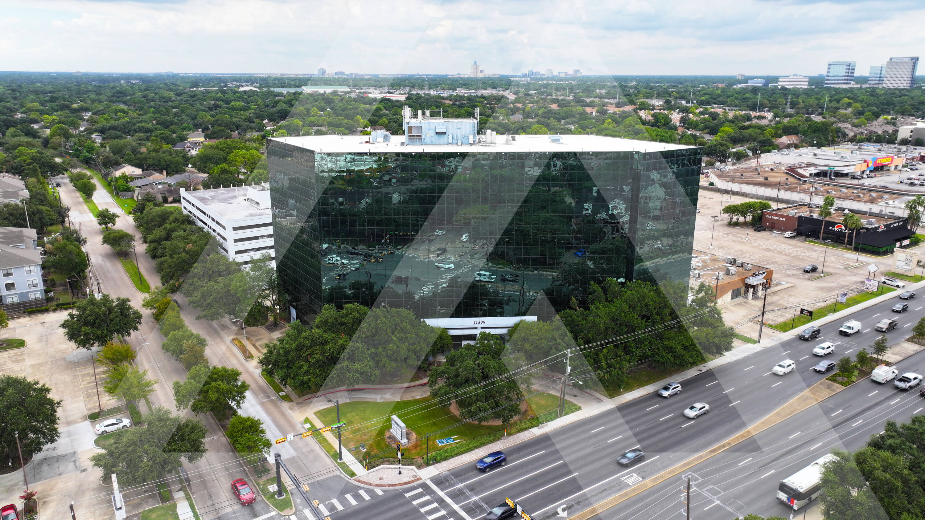 Aerial view of Royal Oaks Centre, a modern retail property with ample parking and glass facade in Houston, TX.