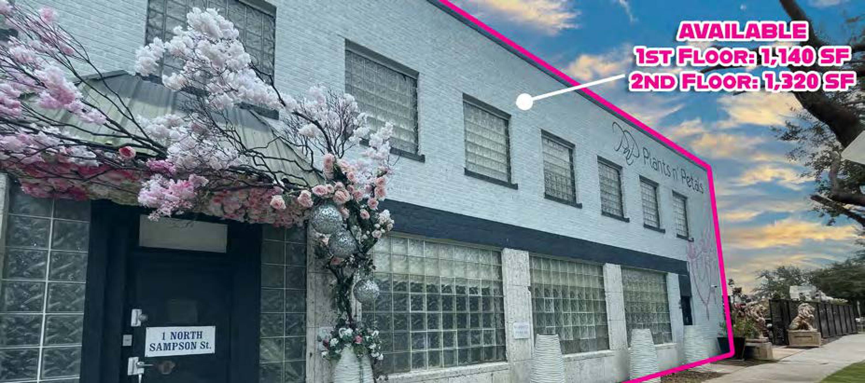 Exterior view of 1 N Sampson St, Houston, TX, showcasing a two-story retail and office building with large windows and decorative cherry blossoms.