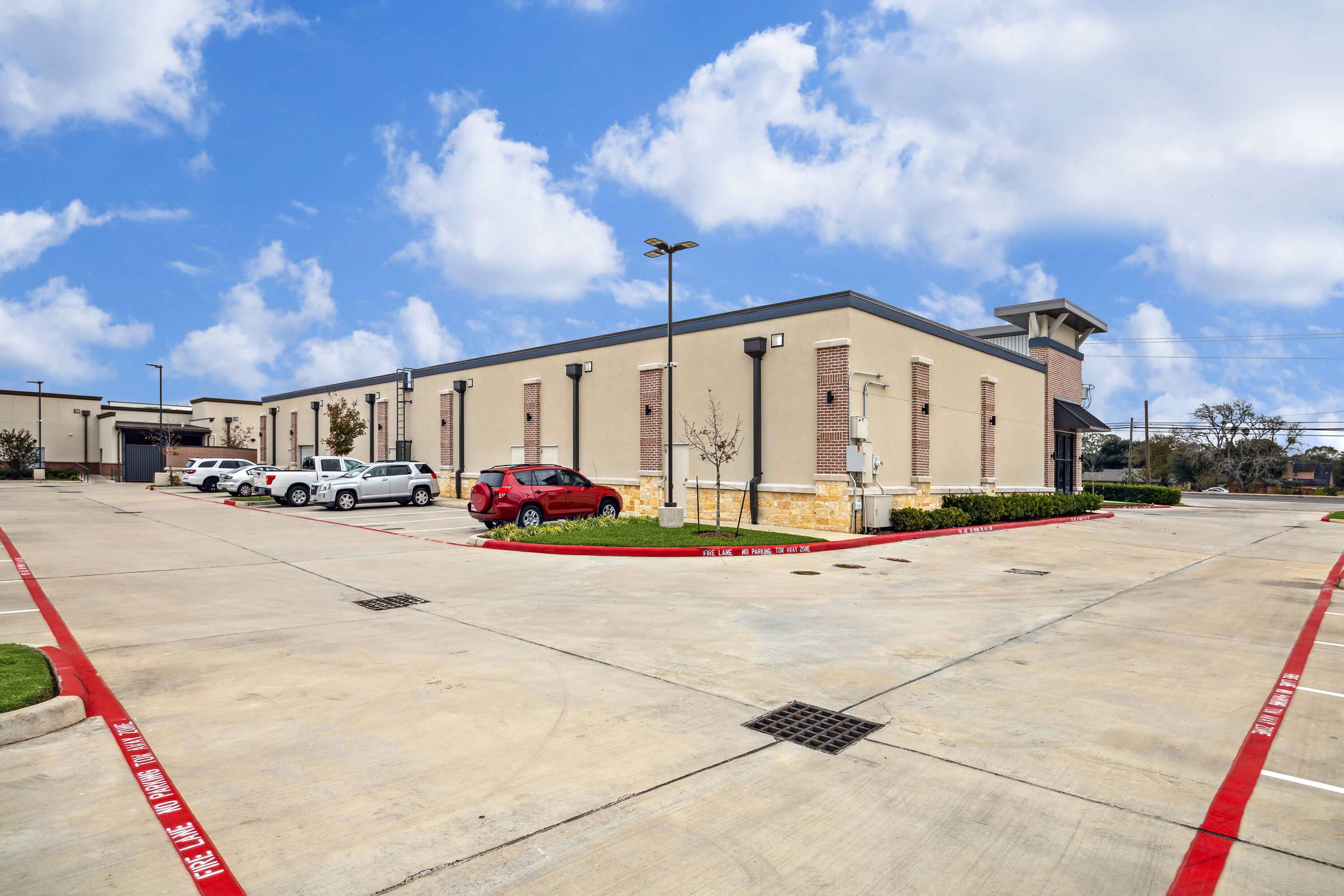 Exterior view of Plantation Creek Retail Center with ample parking and modern facade.