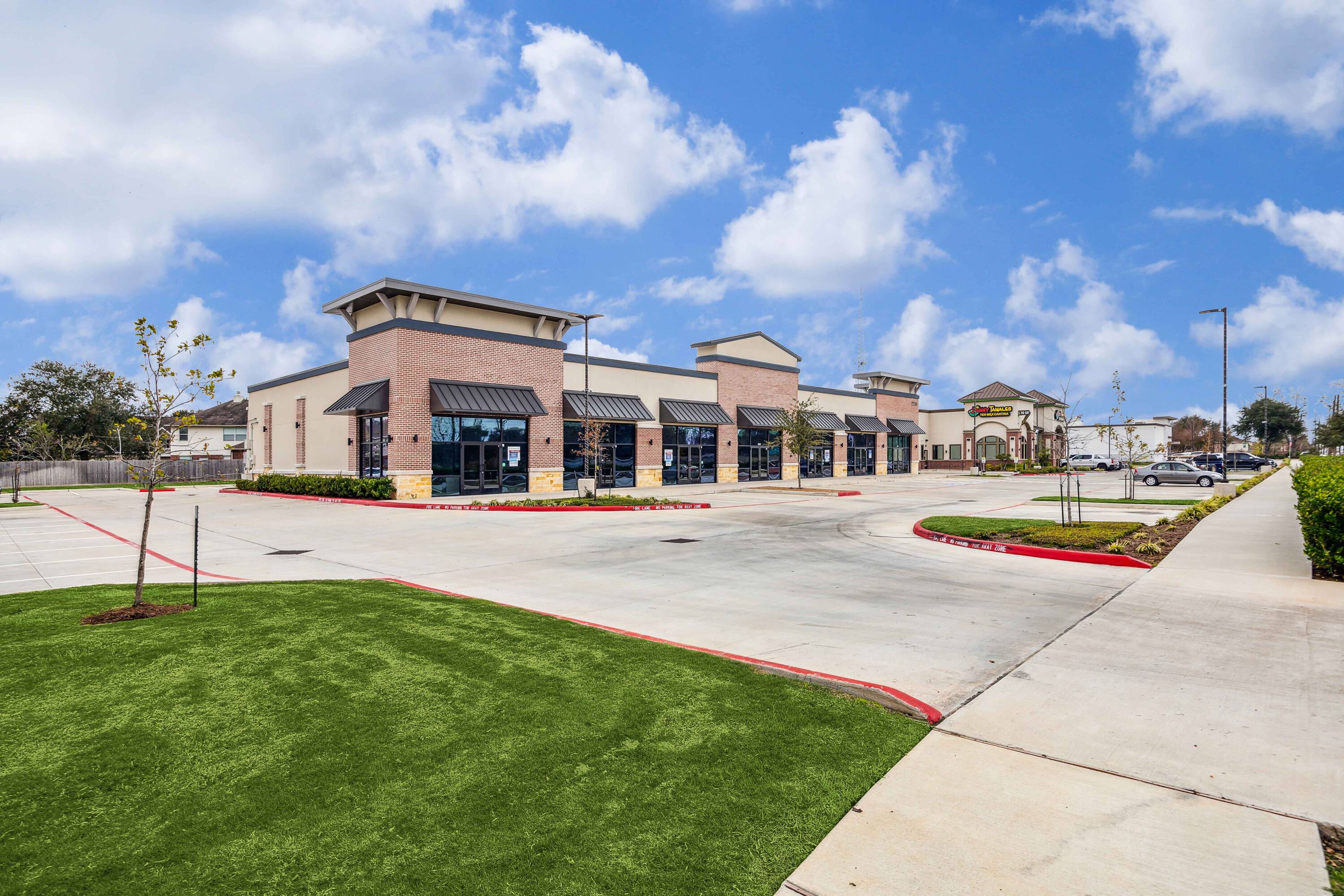 Front view of Plantation Creek Retail Center, a single-story retail strip with ample parking and modern facade.