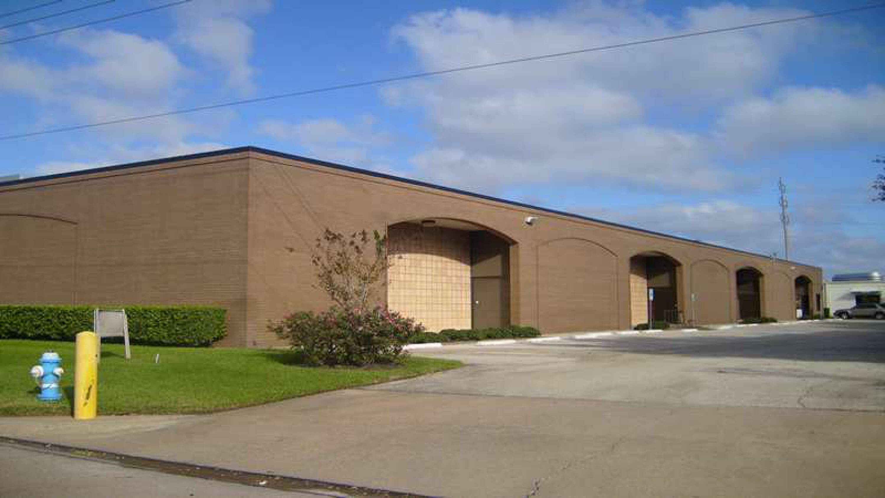 Industrial warehouse building with multiple loading docks and surface parking at 7246 Wynnwood Ln, Houston, TX.
