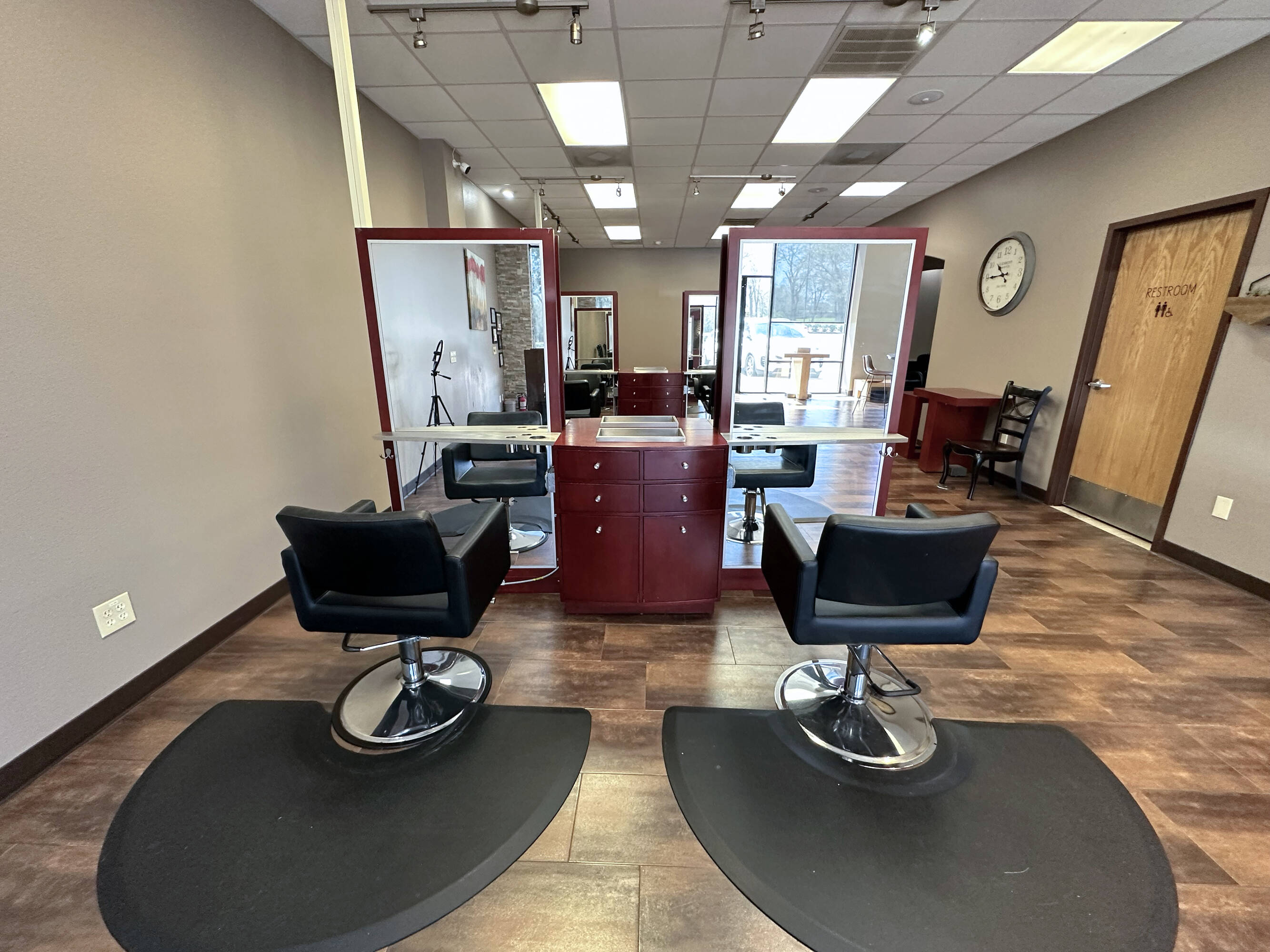 Interior view of a modern salon space with styling chairs, mirrors, and natural light at Westheimer Parkway Retail Center.