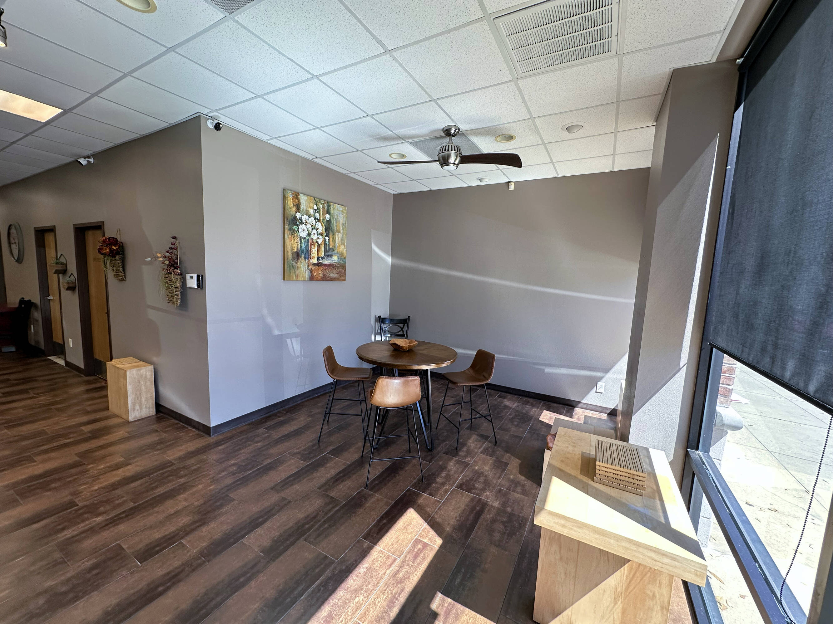 Interior view of a retail space at Westheimer Parkway Retail Center with wooden flooring, large windows, and a seating area.
