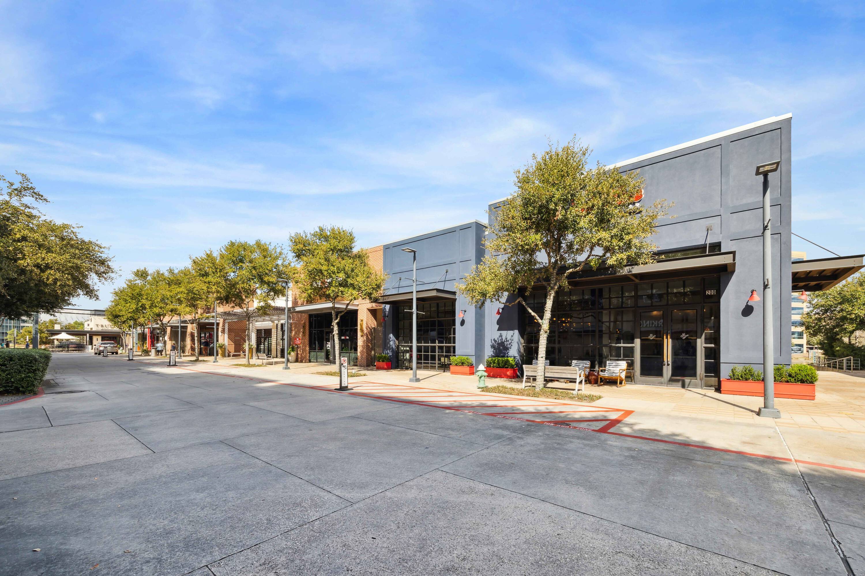 Exterior view of Hughes Landing on Lake Woodlands retail property with modern storefronts and ample natural light.