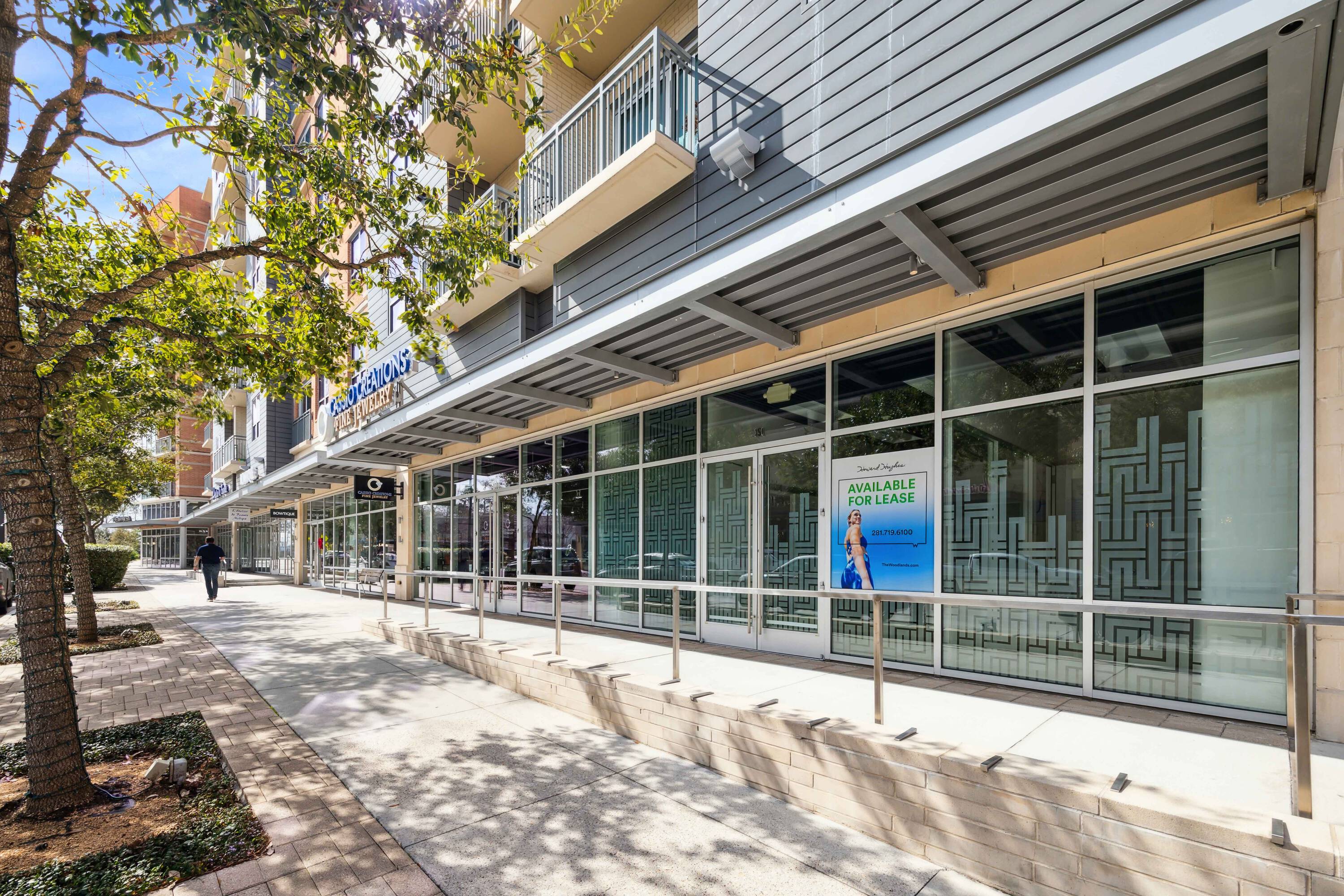 Retail space at Hughes Landing on Lake Woodlands with large windows and outdoor seating area.